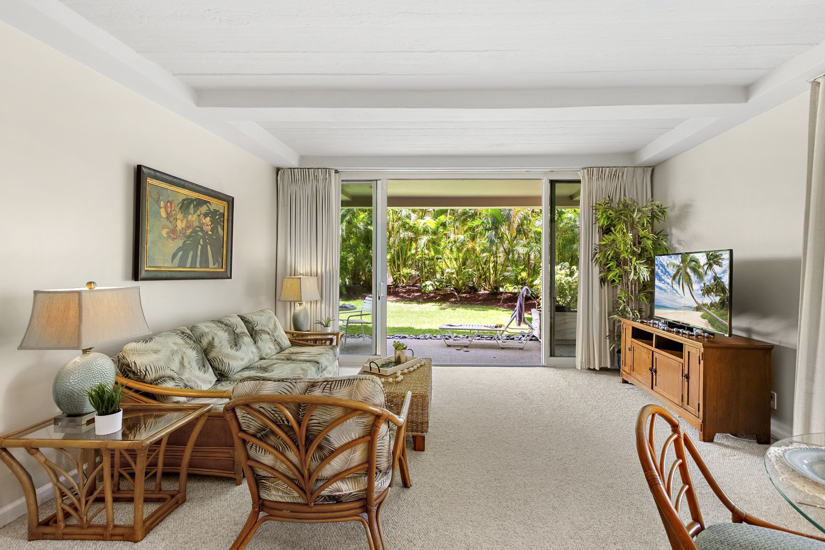 Relax in your tropical living room with garden doors that open to lush greenery and peaceful outdoor spaces.