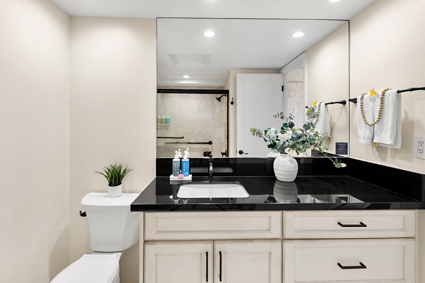 Your private bathroom features polished black granite countertops, a spacious vanity with ample storage, and a bright walk-in shower—fresh towels and thoughtful touches await.