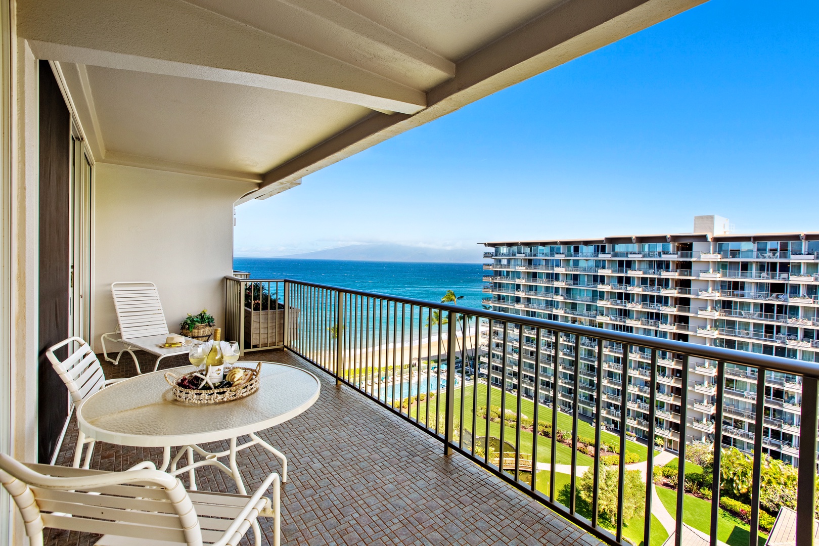 Step onto your private balcony and soak in the stunning ocean views stretching to the horizon, with tropical gardens below and neighboring buildings dotting the coast.