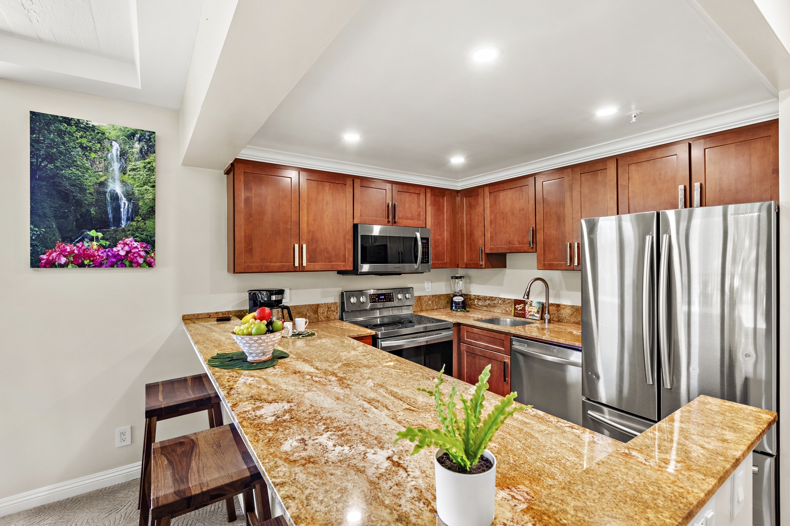 Bright and inviting open-concept kitchen featuring cabinetry, sleek countertops, and a spacious island that flows seamlessly into the living and dining areas. Perfect for entertaining or relaxing in comfort.