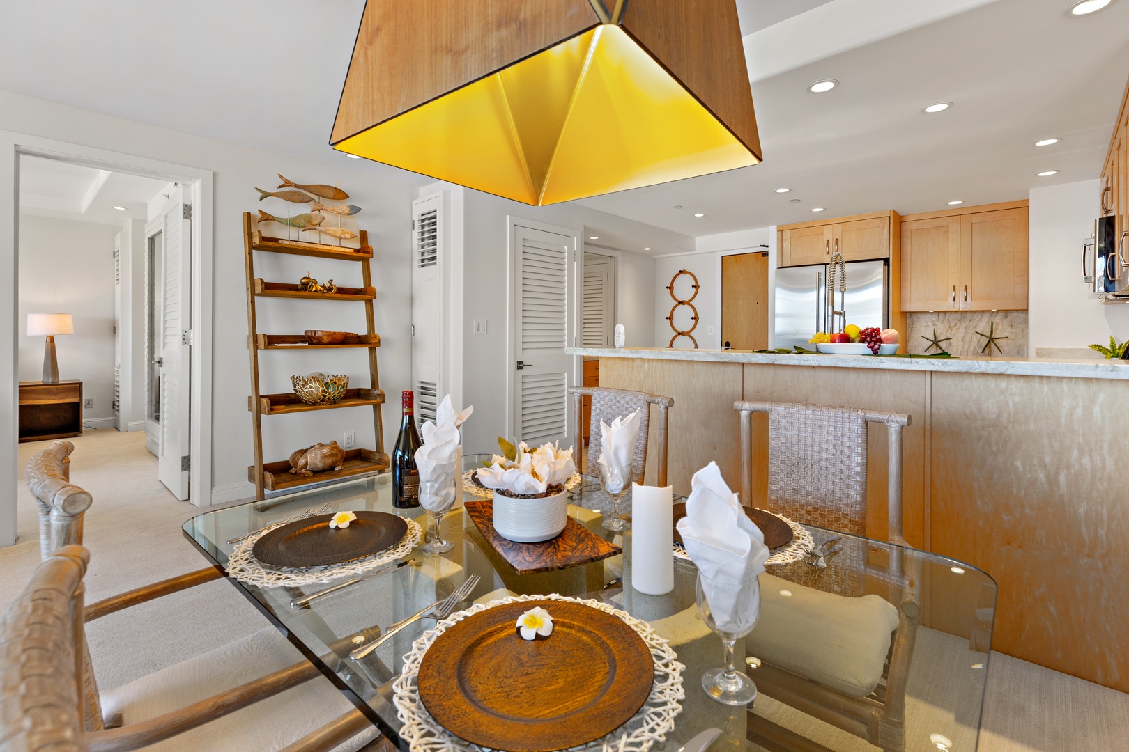 Gather at the beautifully set dining table, where beach-inspired decor and an open-concept design invite you to enjoy meals under the warm glow of a striking pendant light.