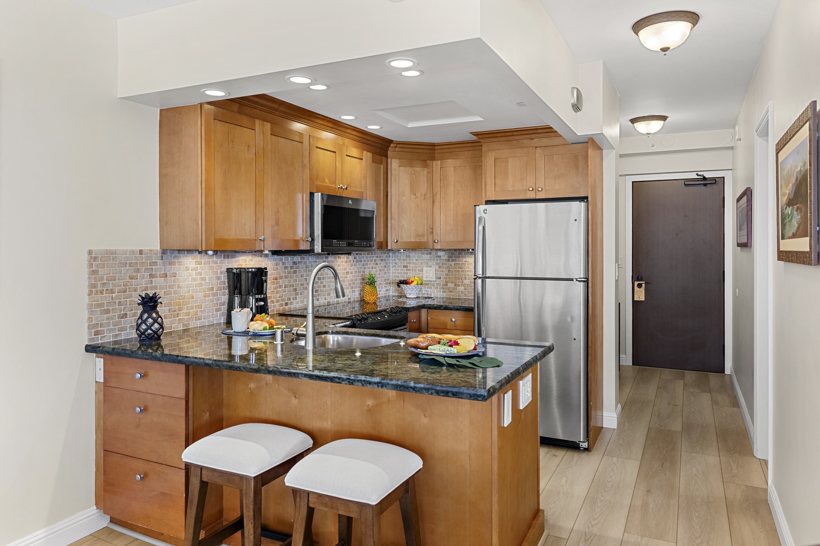 Your gourmet kitchen awaits with granite counters, stainless appliances, and a breakfast bar perfect for morning coffee or evening wine.
