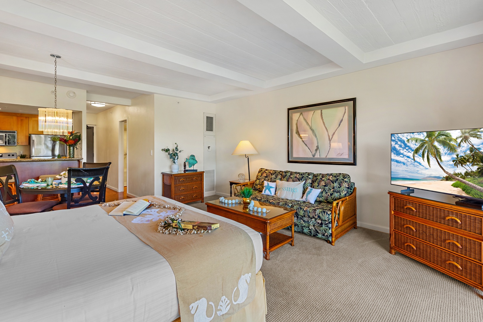 Unwind in your tropical haven with a king bed, full kitchen, and island-inspired decor beneath exposed beams and a palm leaf ceiling fan.