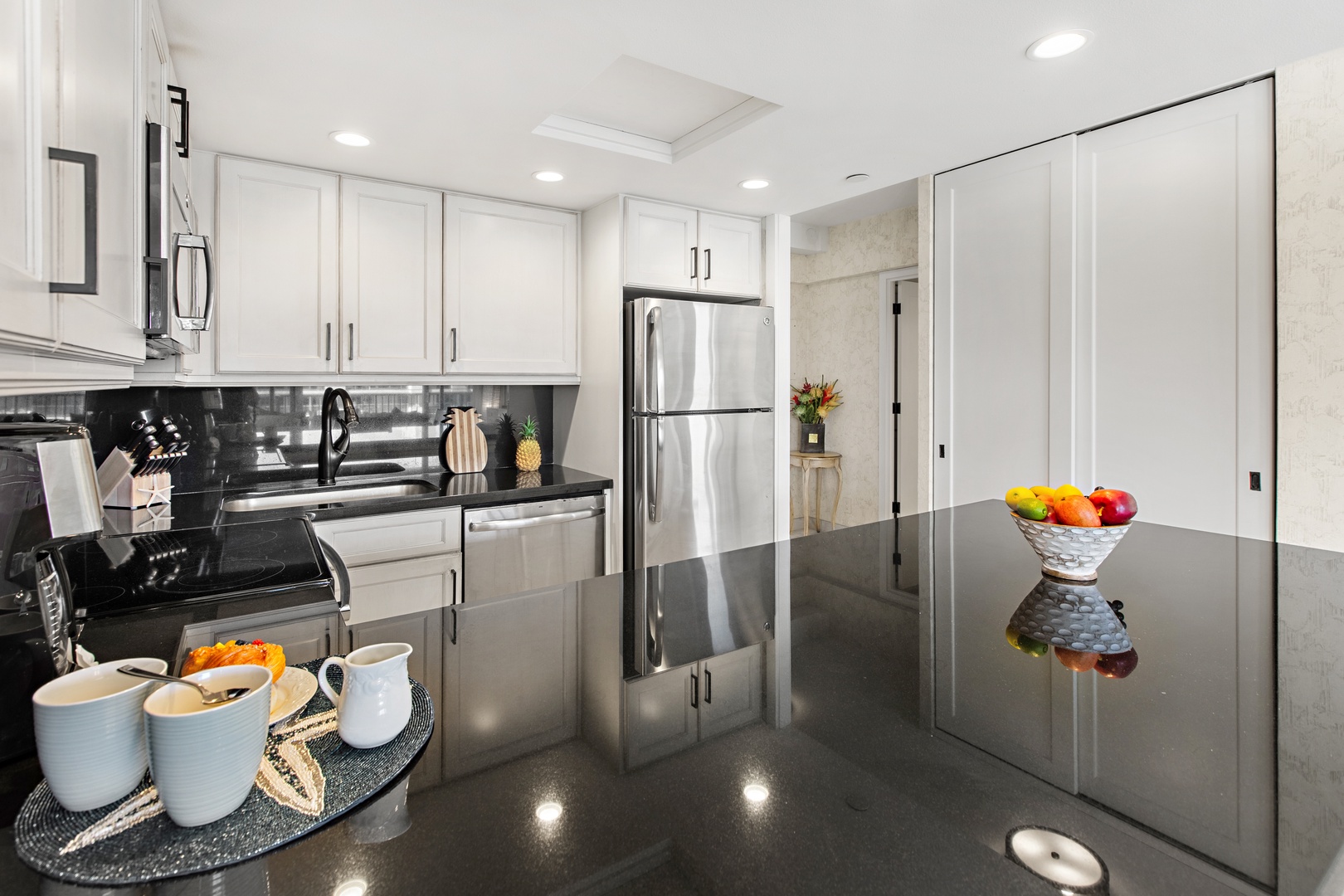 Your fully equipped kitchen awaits, featuring sleek granite counters, stainless steel appliances, and bright white cabinetry—perfect for preparing meals and gathering over morning coffee.