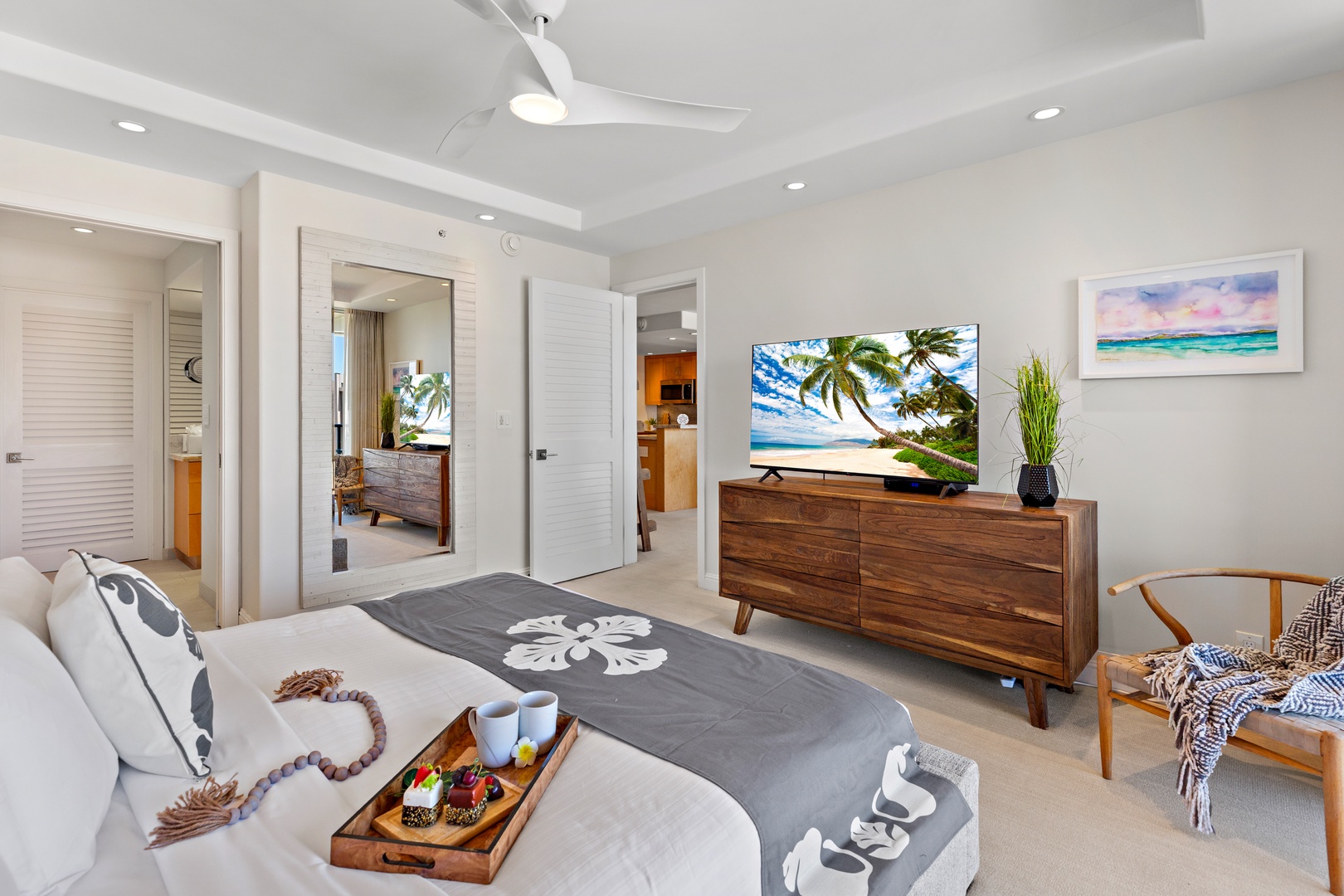 Unwind in your tranquil bedroom retreat with coastal touches, crisp linens, and tropical breezes from the ceiling fan. Enjoy morning coffee in bed while palm trees sway on screen.