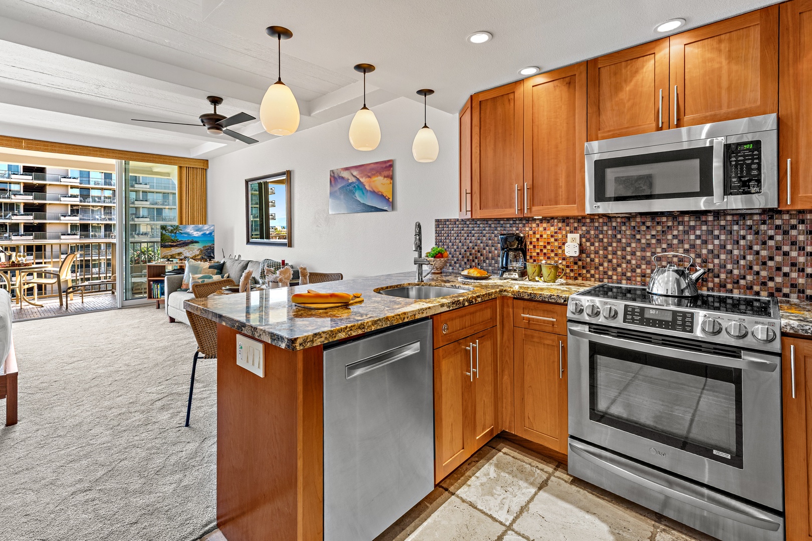 Your open-concept kitchen features granite countertops, stainless appliances, and a cozy island—perfect for whipping up tropical meals while natural light pours in from your private balcony beyond.