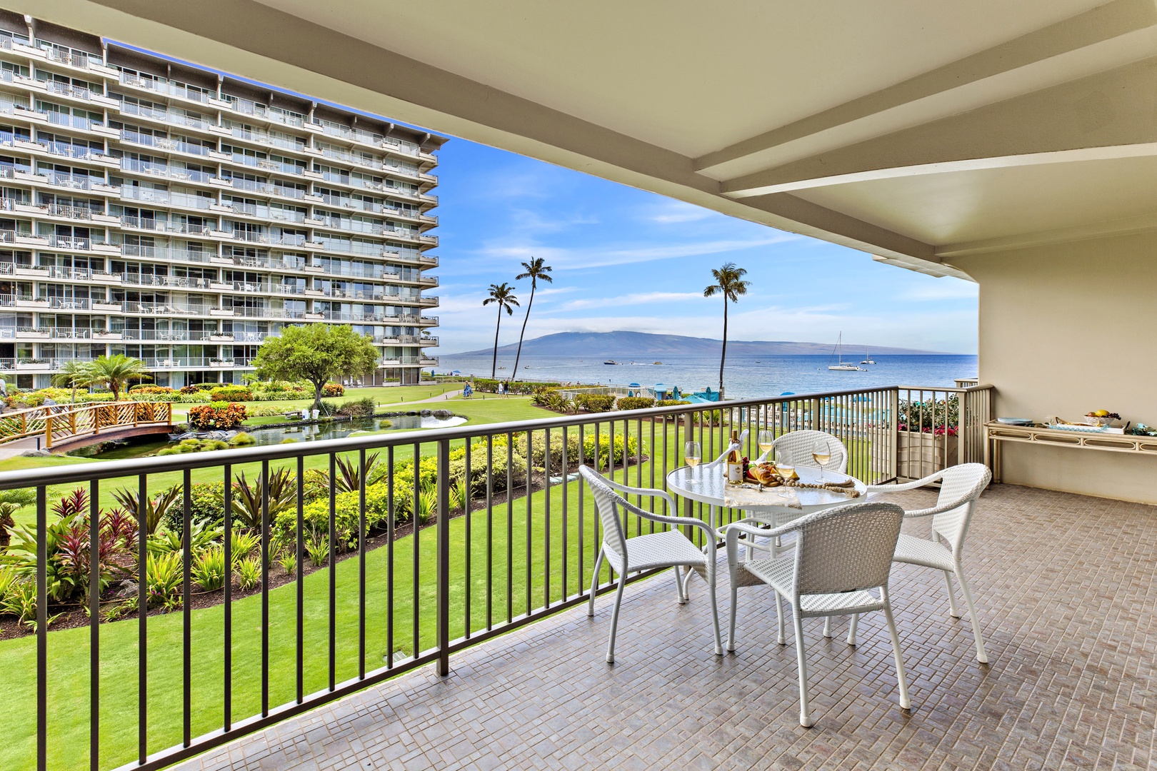 Savor your morning coffee on this spacious balcony with stunning ocean views, tropical palms, and manicured gardens stretching to the horizon.