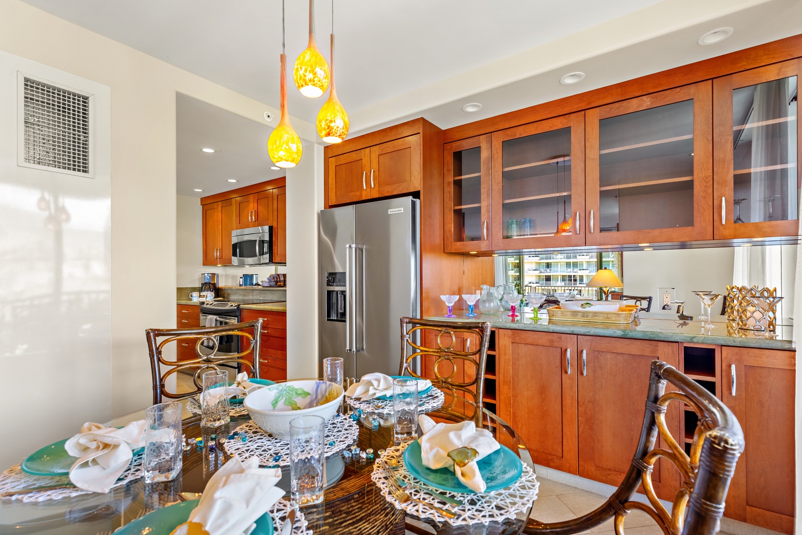 Gather around the elegantly set dining table in your gourmet kitchen, where gleaming appliances and warm wood tones create an inviting space for memorable meals together.
