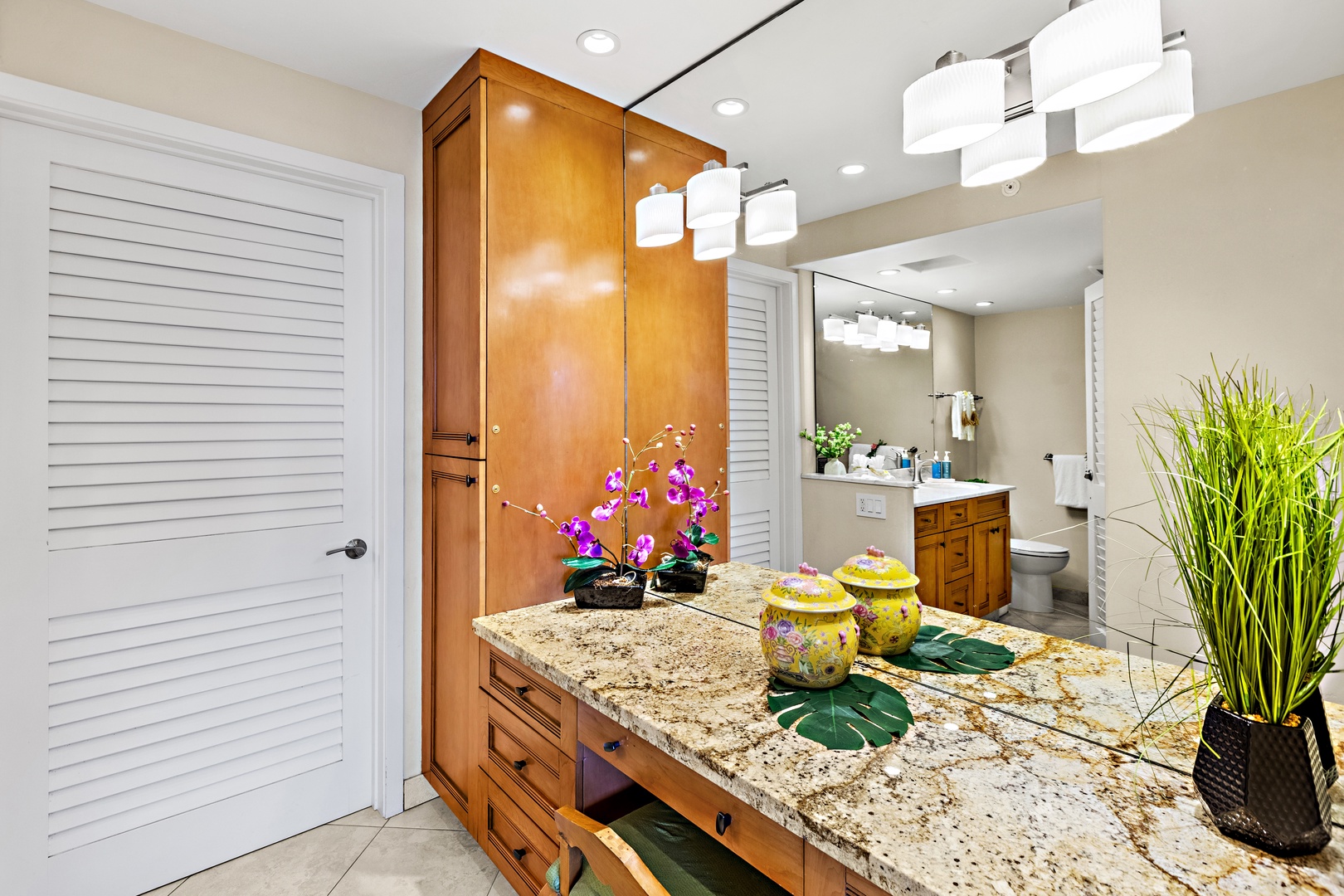 Pamper yourself in this elegant bathroom with granite counters, warm wood cabinets, and beautiful orchid accents.