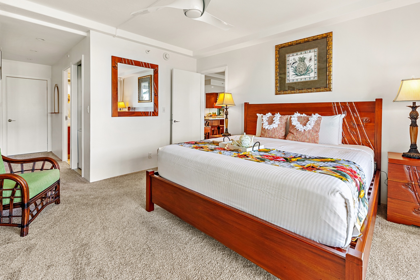 Spacious island-inspired retreat featuring a comfortable king-size bed, rich wood furnishings, cozy tropical accents, and a bright inviting bedroom space.