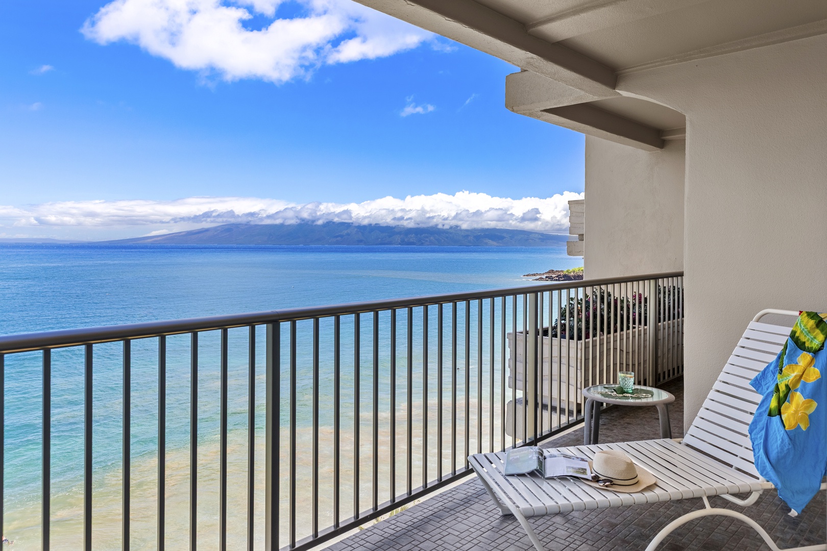 Oceanfront balcony offers stunning sea and mountain views with lounge seating for ultimate coastal relaxation.