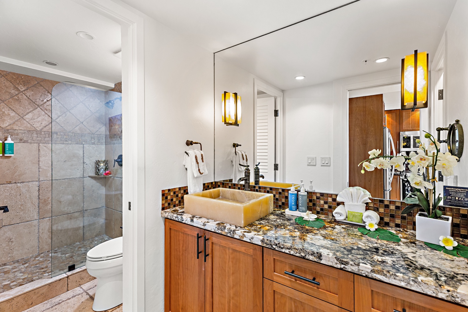 Your private spa-like bathroom features a spacious walk-in shower, elegant granite countertops, warm wood cabinetry, and stylish fixtures that make every moment feel luxurious.