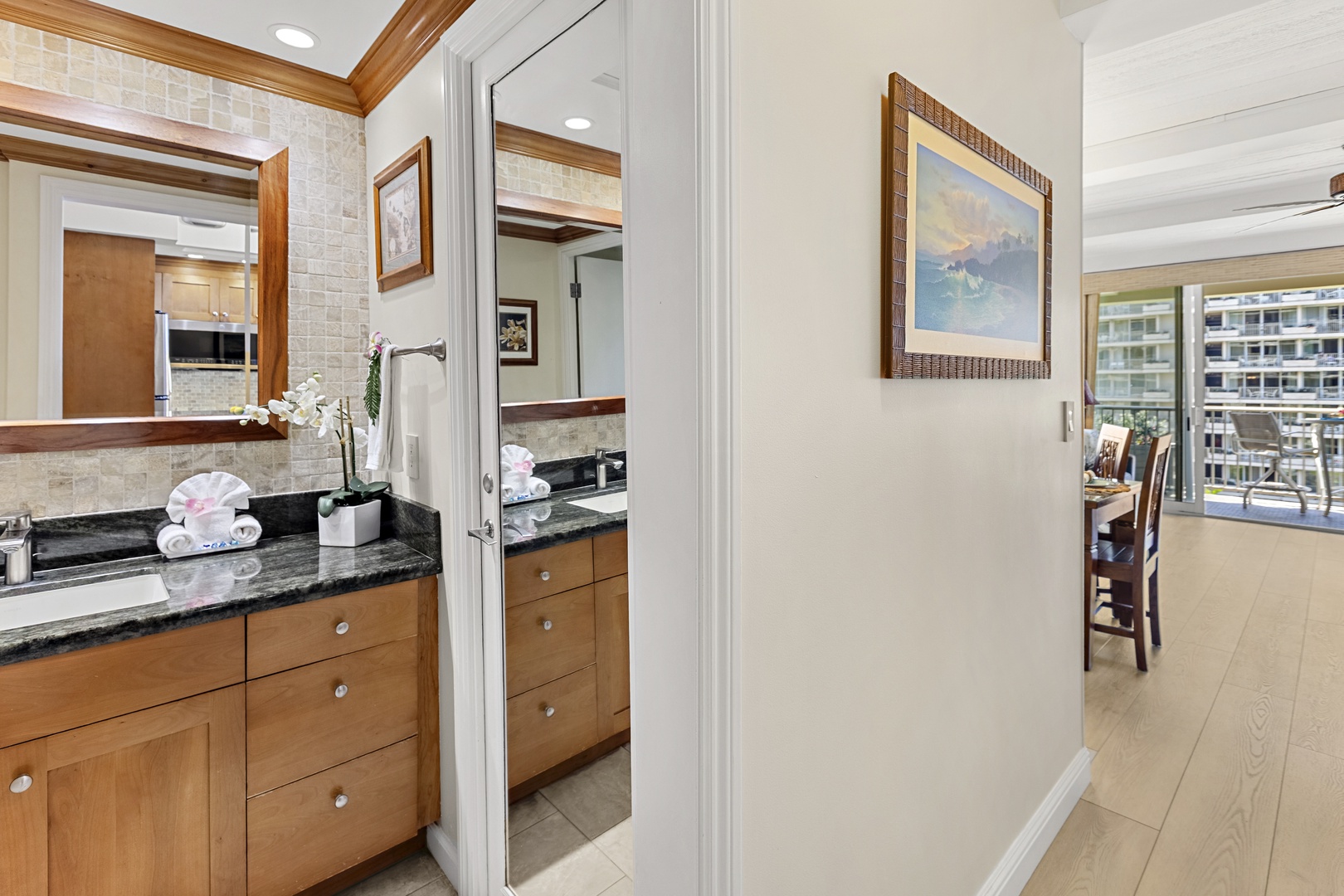 Your spacious kitchen features gleaming granite counters, warm wood cabinets, and thoughtful touches like fresh orchids welcoming you home.