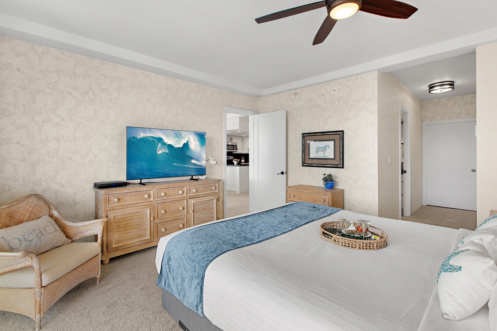 Sink into crisp white linens and soft accent pillows after a day of adventure. Your coastal bedroom features warm wood furnishings, a ceiling fan to keep you comfortable, and a smart TV for unwinding before bed.