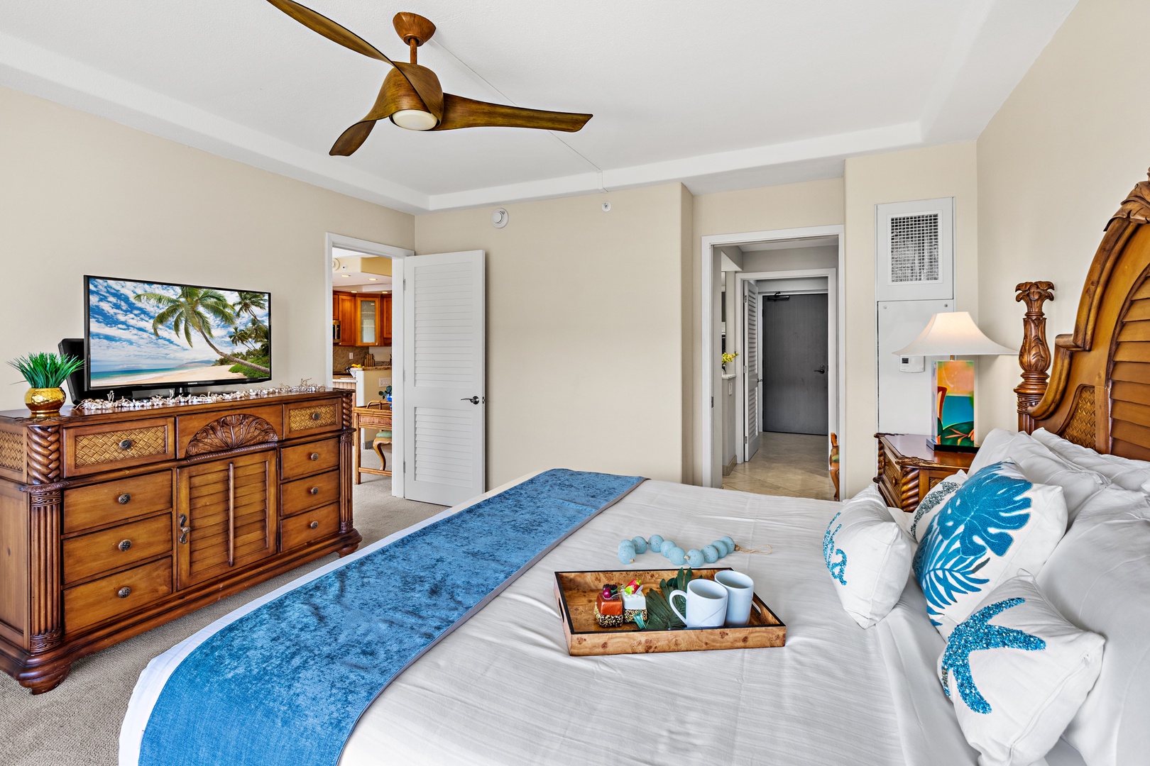 Your tropical-themed bedroom features warm wood furnishings, a ceiling fan for comfort, and thoughtful amenities like room service.