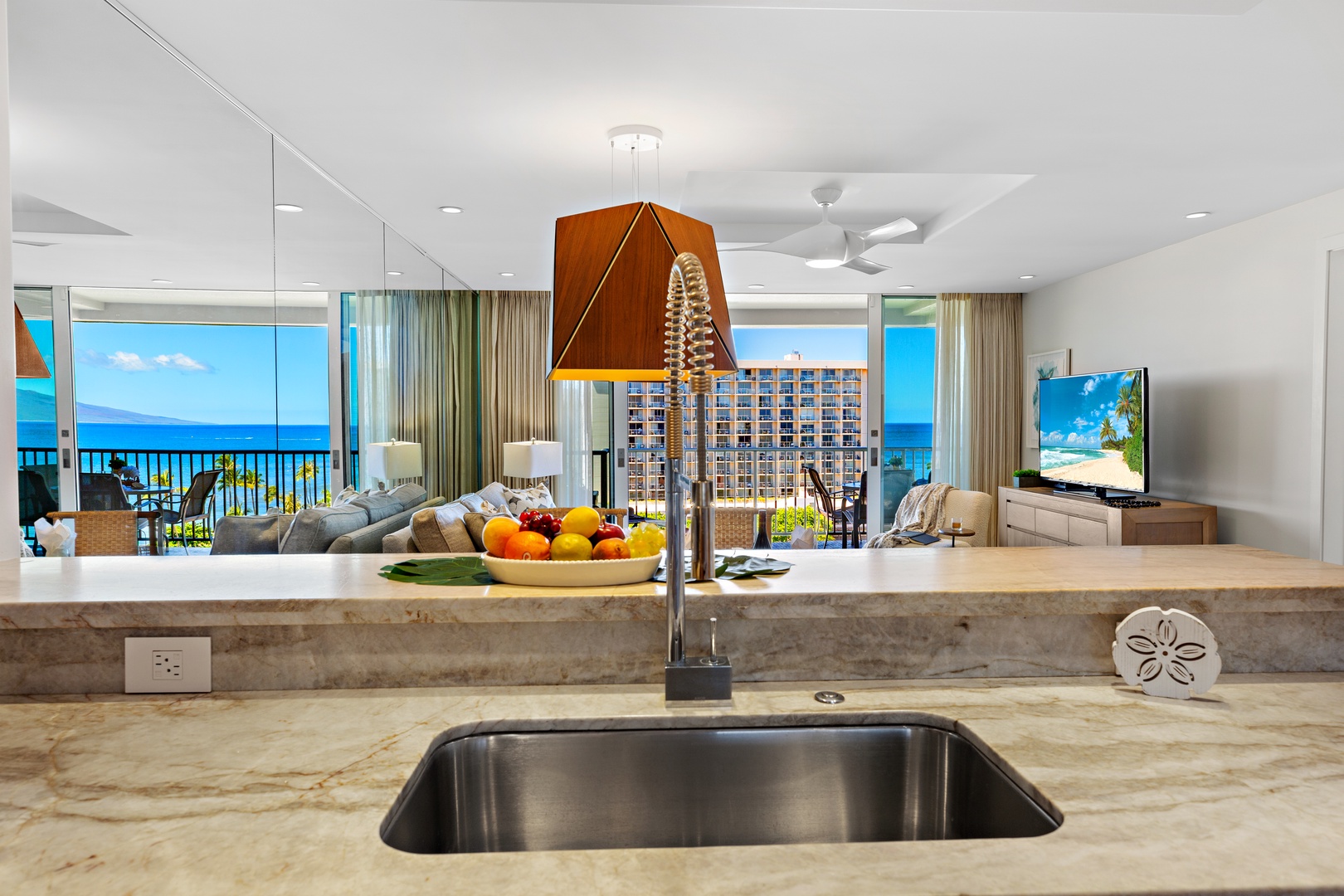 Prepare fresh meals in your fully-equipped kitchen while savoring stunning ocean views through floor-to-ceiling windows. The open layout seamlessly connects cooking, dining, and relaxing spaces for your perfect beach getaway.