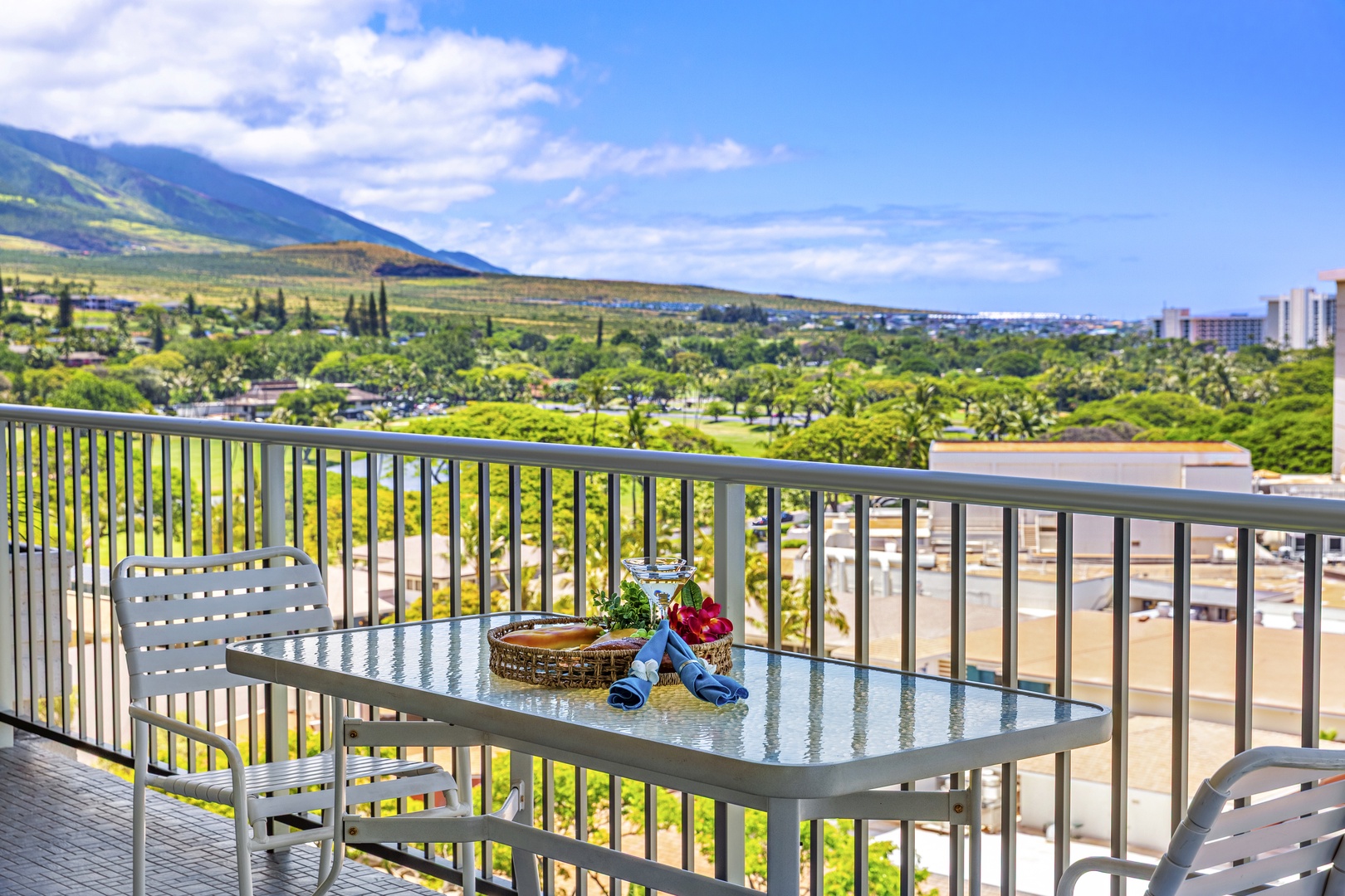 Sip your morning coffee on this breezy balcony, where sweeping mountain and city views stretch out before you, framed by lush greenery below.