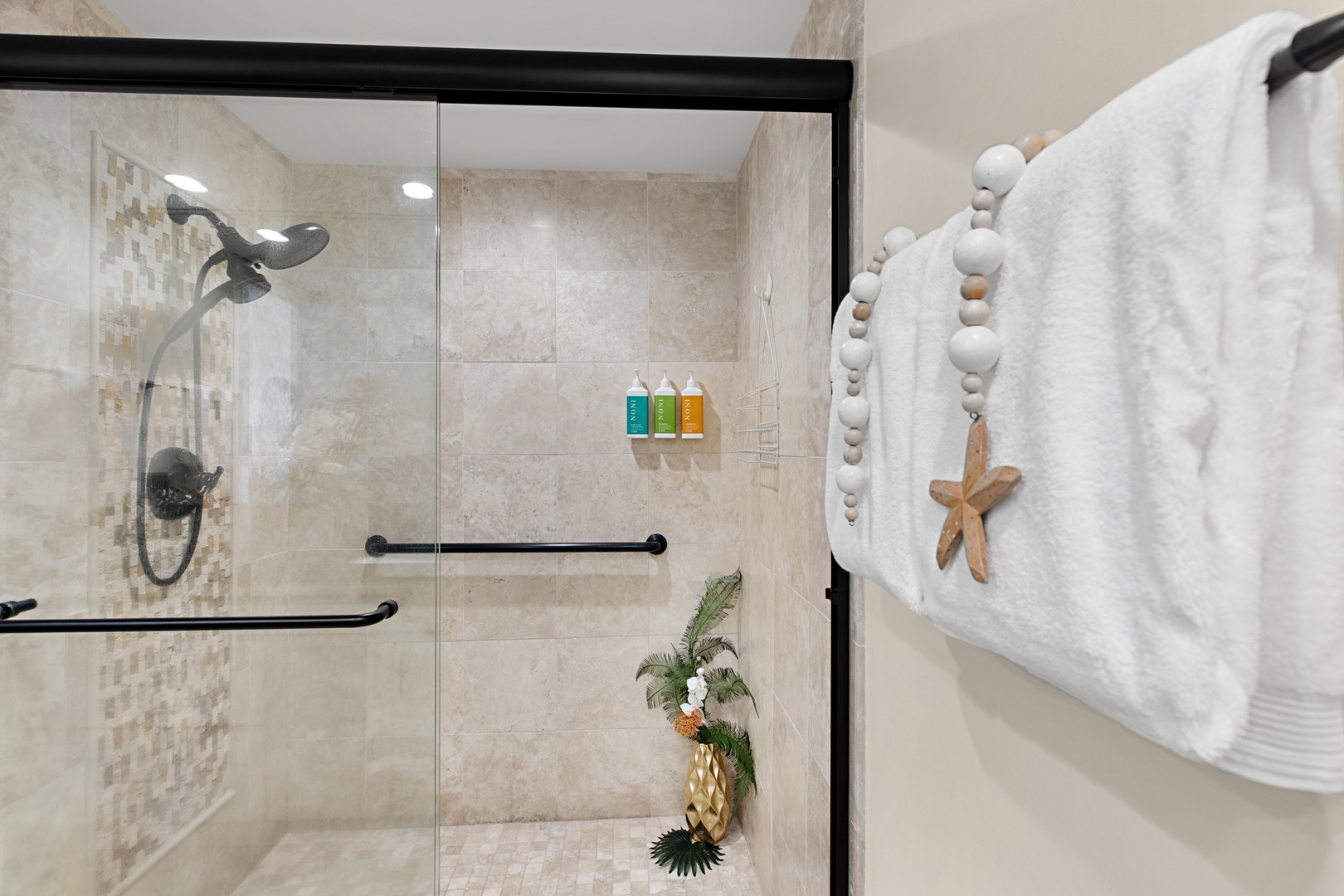 Step into your spa-inspired sanctuary featuring a spacious walk-in shower with modern glass enclosure, grab bars for safety, and soft tiled walls that invite relaxation.