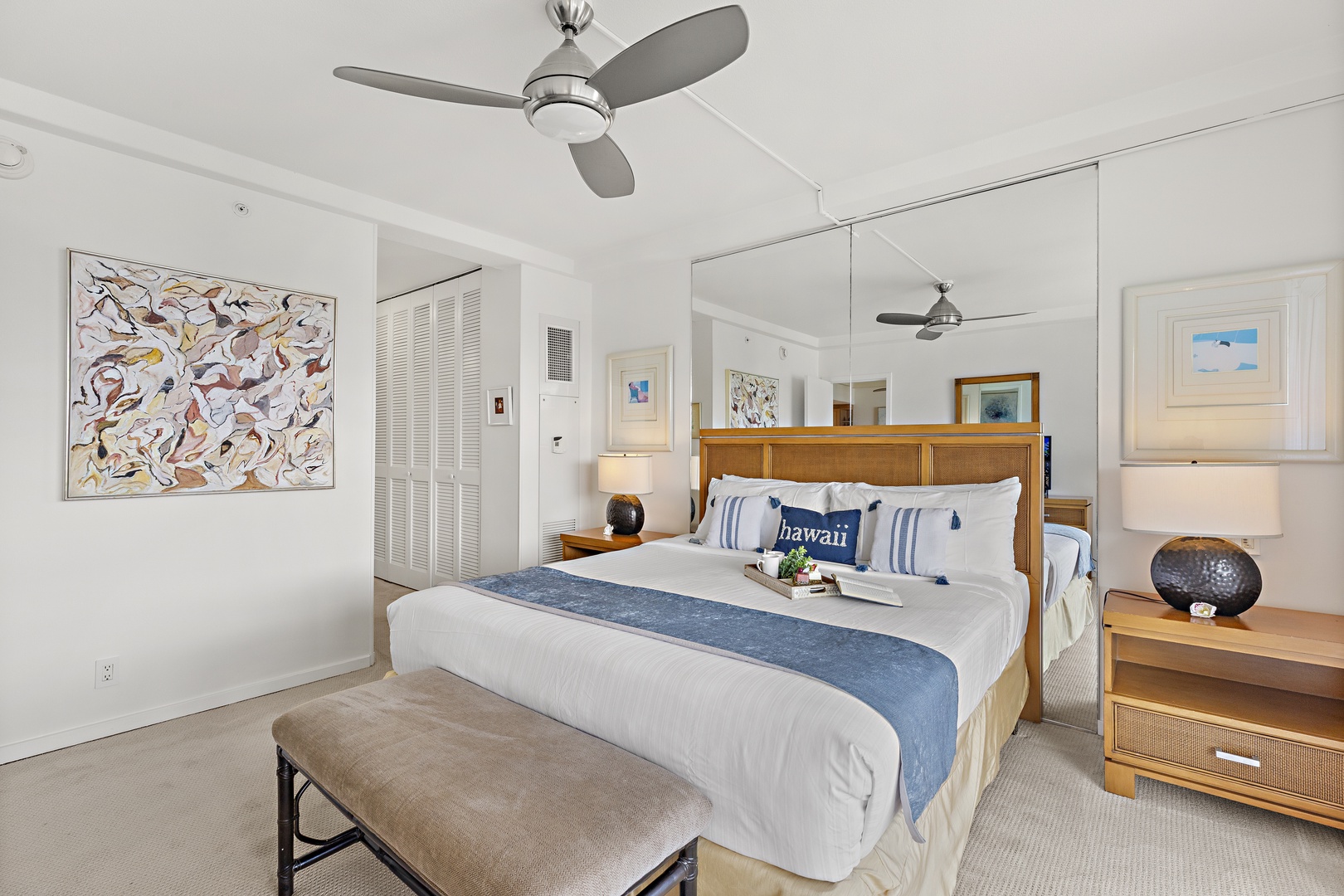 Unwind in a bright, coastal-inspired bedroom where tropical breezes keep you cool beneath a stylish ceiling fan. Crisp linens and elegant island touches invite restful nights.