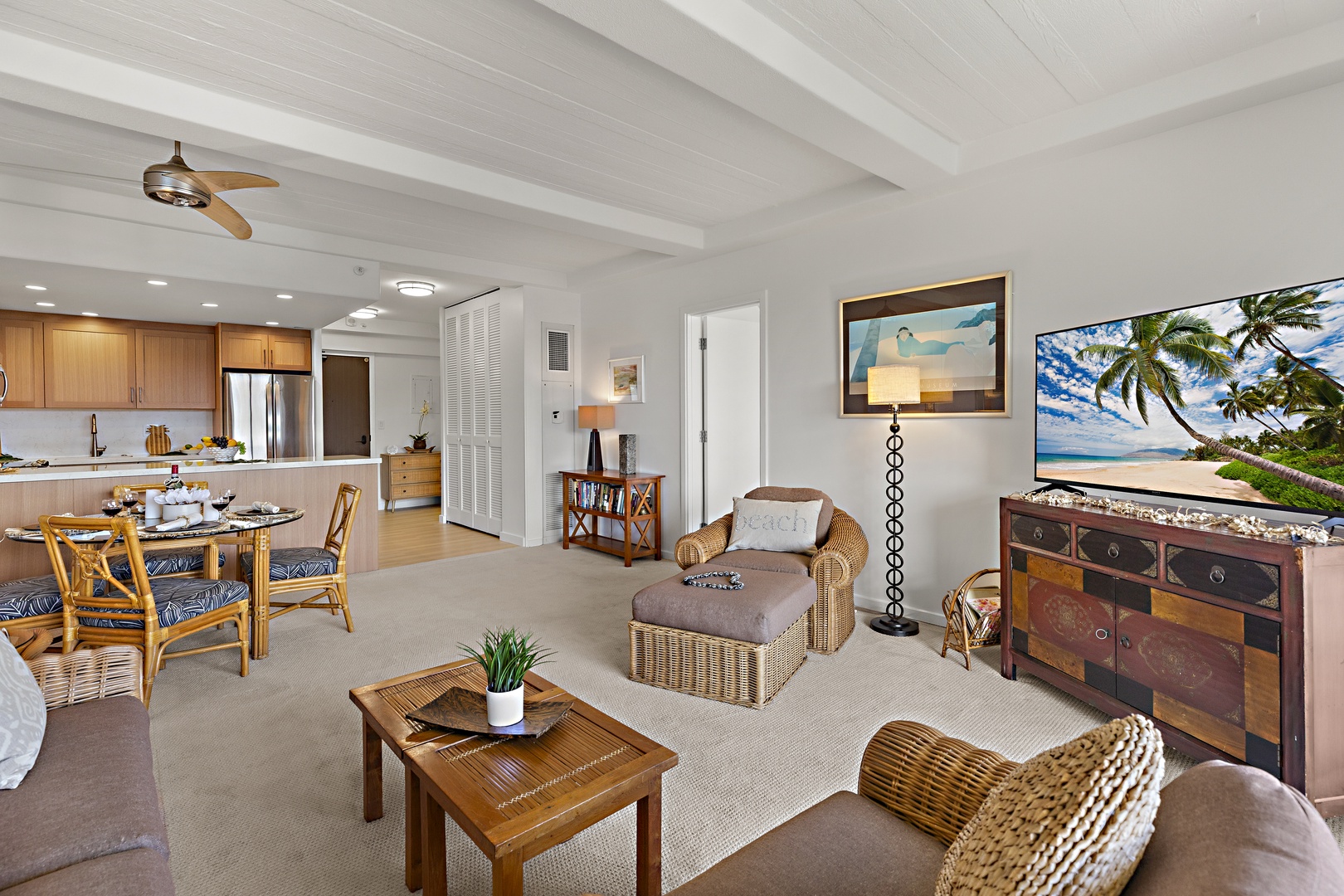 Relax in your open-concept living and dining space featuring elegant wood accents, coastal décor, and airy white ceilings that invite natural light to flow throughout your island retreat.