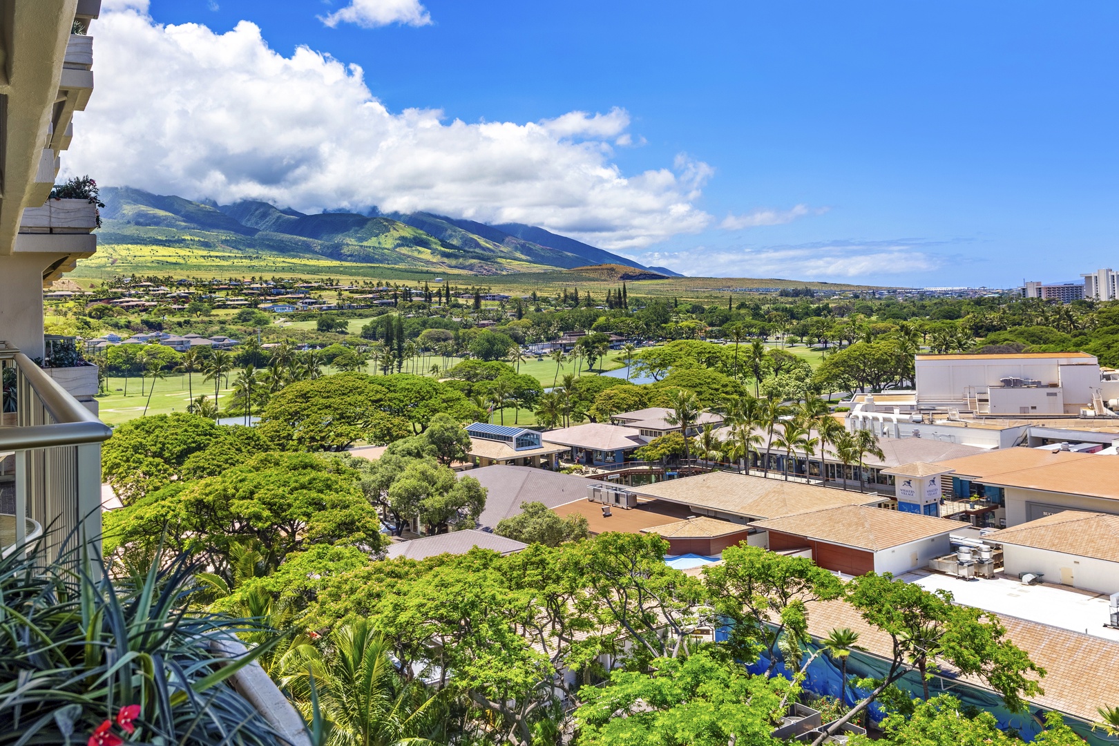 Sweeping mountain views meet lush greenery and golf course vistas, framed by this elevated vantage point in a serene tropical setting.