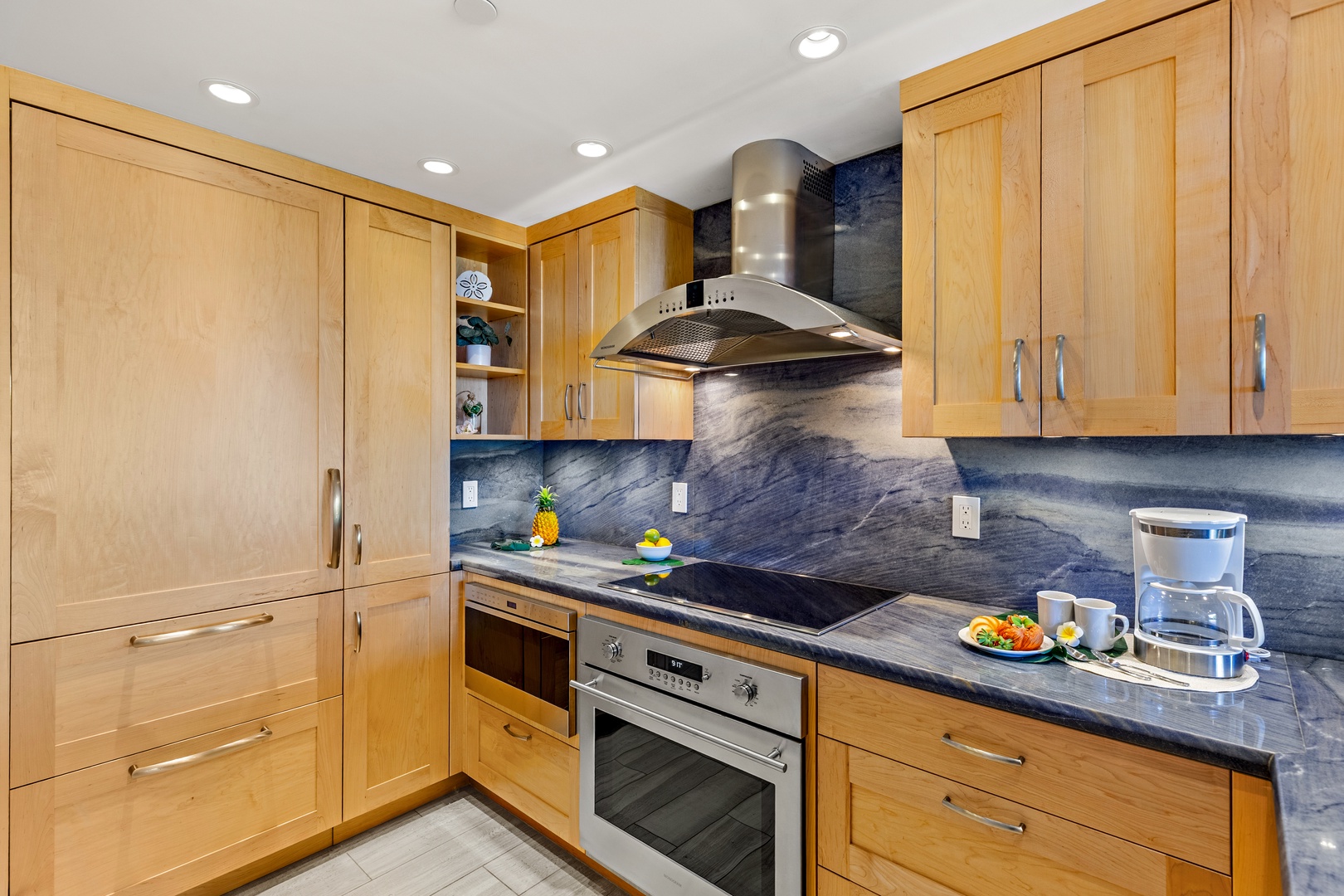 Step into a beautifully appointed kitchen where warm wood cabinetry meets sleek stone countertops. Modern appliances and ample storage make preparing your favorite meals a joy in this inviting space.