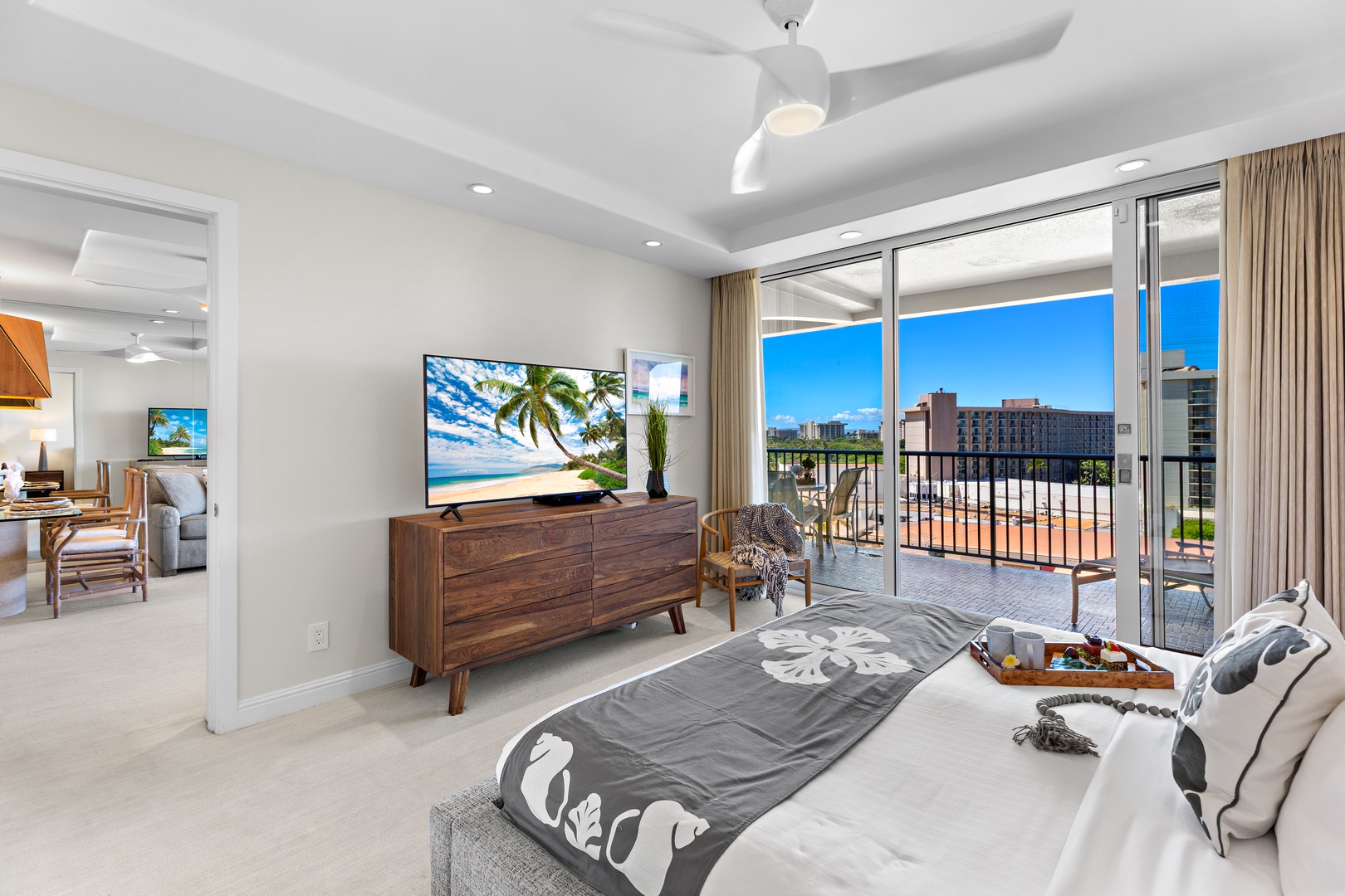 Wake up in your bright, modern bedroom with tropical breezes and a private balcony overlooking the vibrant city and lush landscaping, where every morning feels like paradise.