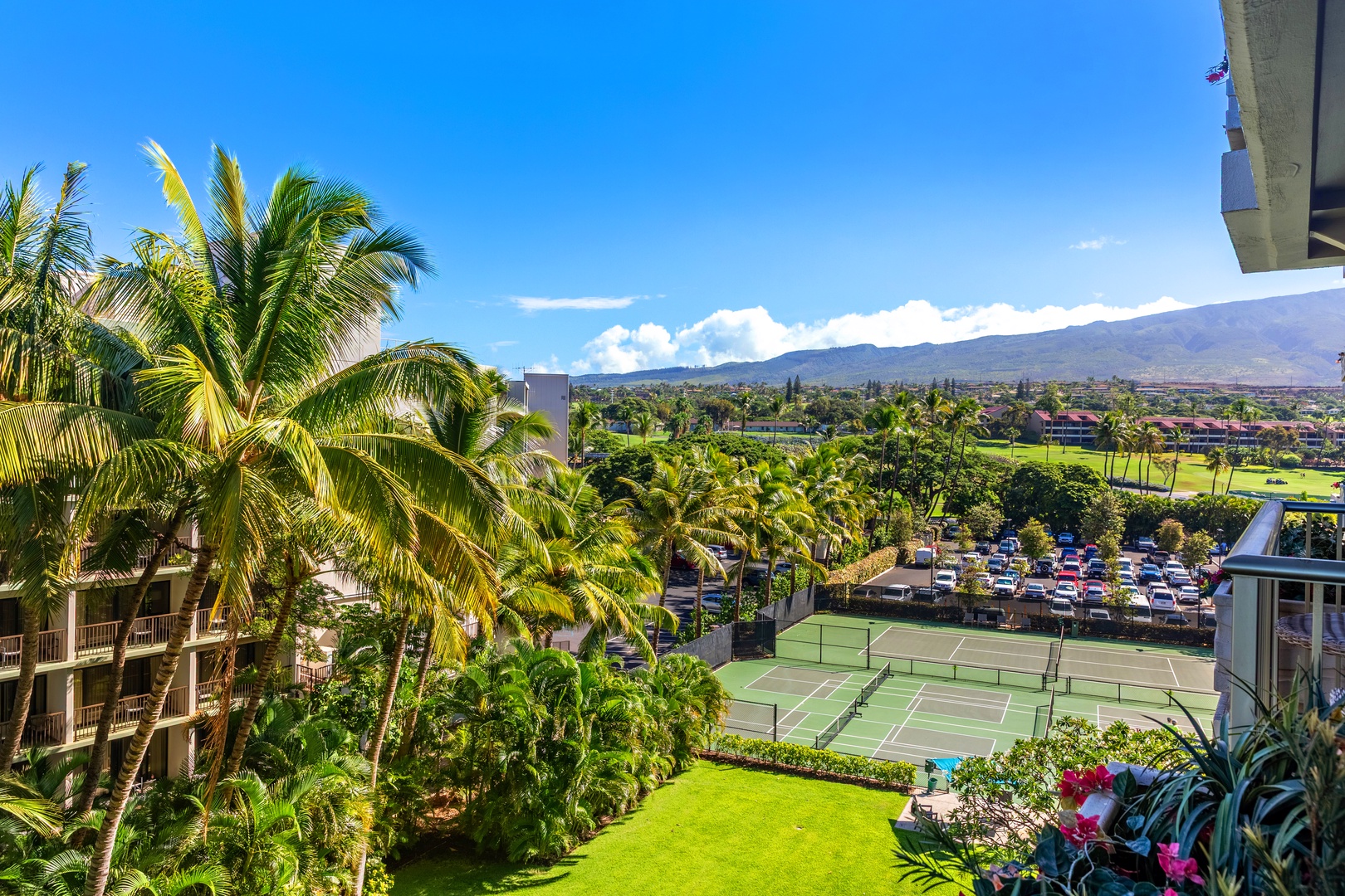 Expansive balcony with panoramic views of lush landscapes and distant mountains, featuring comfortable seating for relaxation.