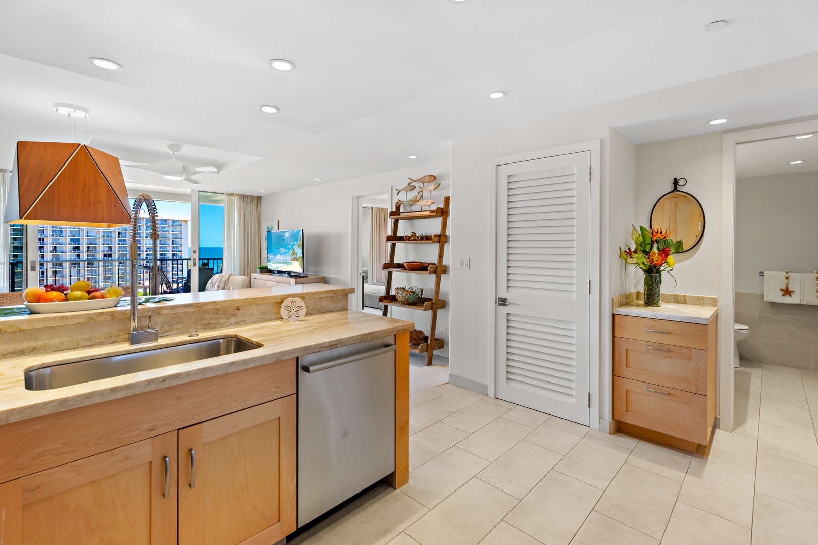 Your fully-equipped kitchen flows into a bright living area with stunning ocean views, offering a perfect space to prepare meals and unwind in tropical comfort.