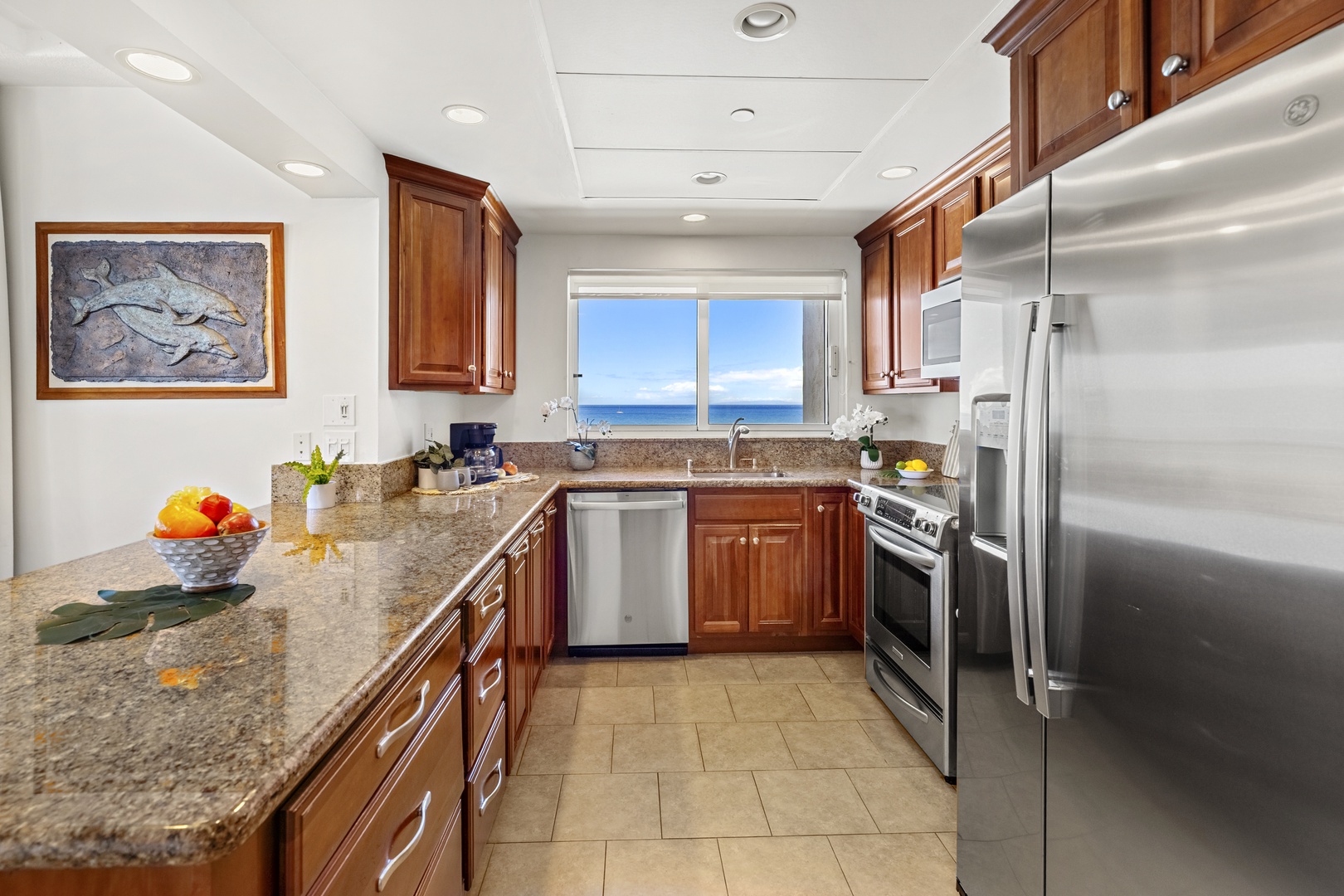 Your gourmet kitchen awaits, featuring rich wood cabinetry, granite countertops, and stainless steel appliances. Step up to the window while you cook and soak in breathtaking ocean views.