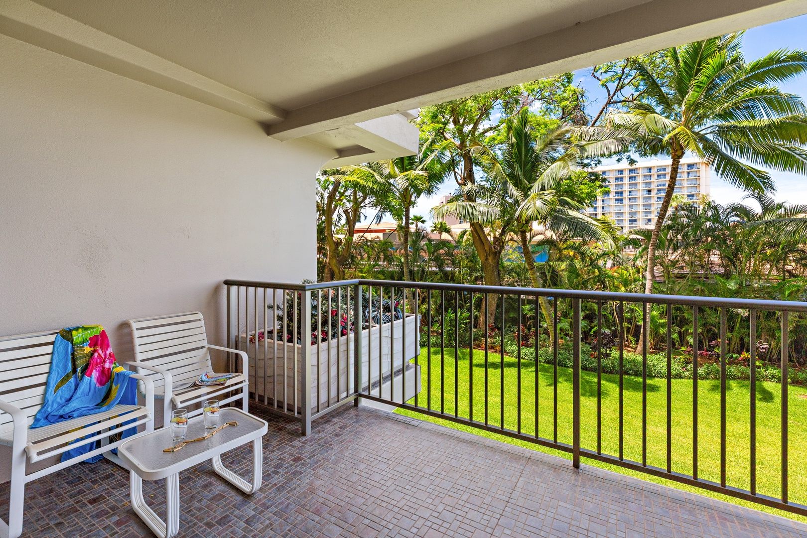 Your private balcony overlooks lush tropical gardens with swaying palms, offering a peaceful escape where you can sip your morning coffee surrounded by nature's beauty.