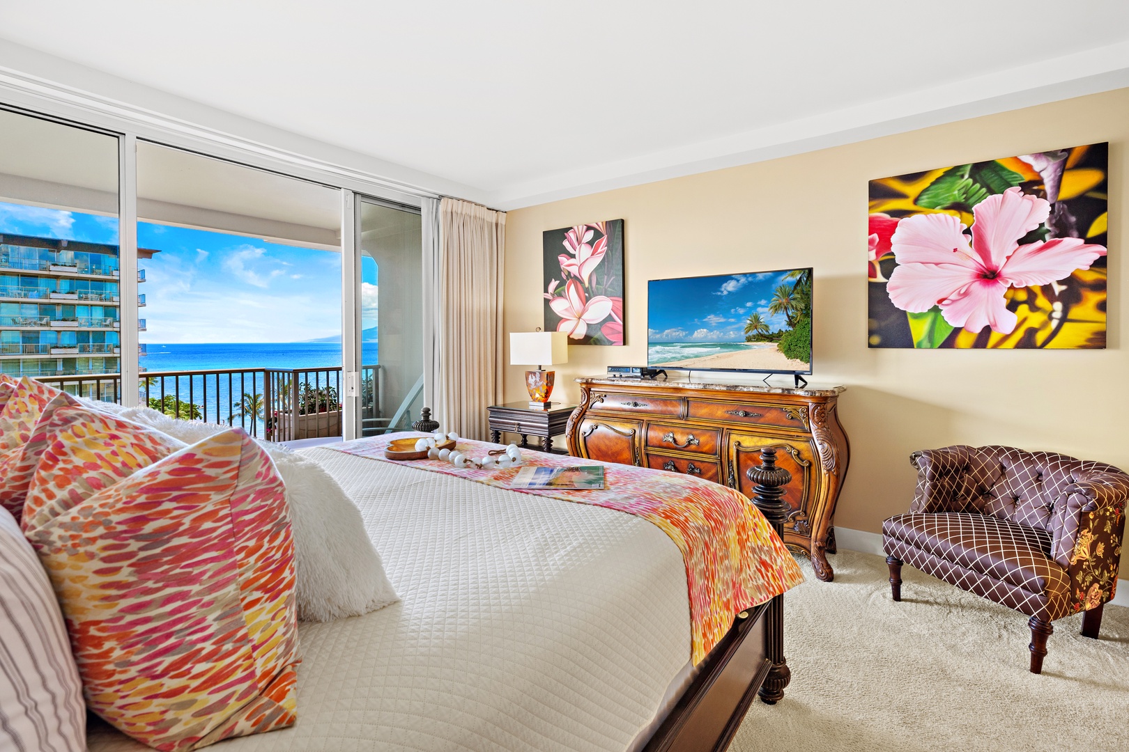 Wake up to stunning ocean panoramas through floor-to-ceiling windows that frame your private balcony and the endless blue horizon beyond—tropical elegance meets seaside serenity in your beautifully appointed bedroom.