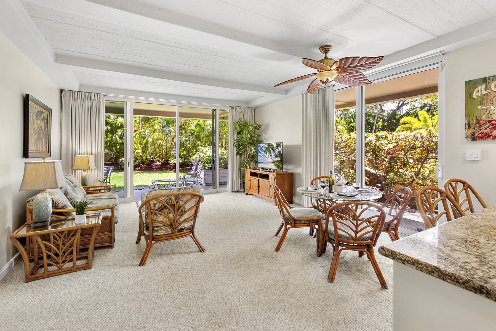 Your bright, tropical living space flows seamlessly to lush gardens through floor-to-ceiling windows, creating an indoor-outdoor paradise.