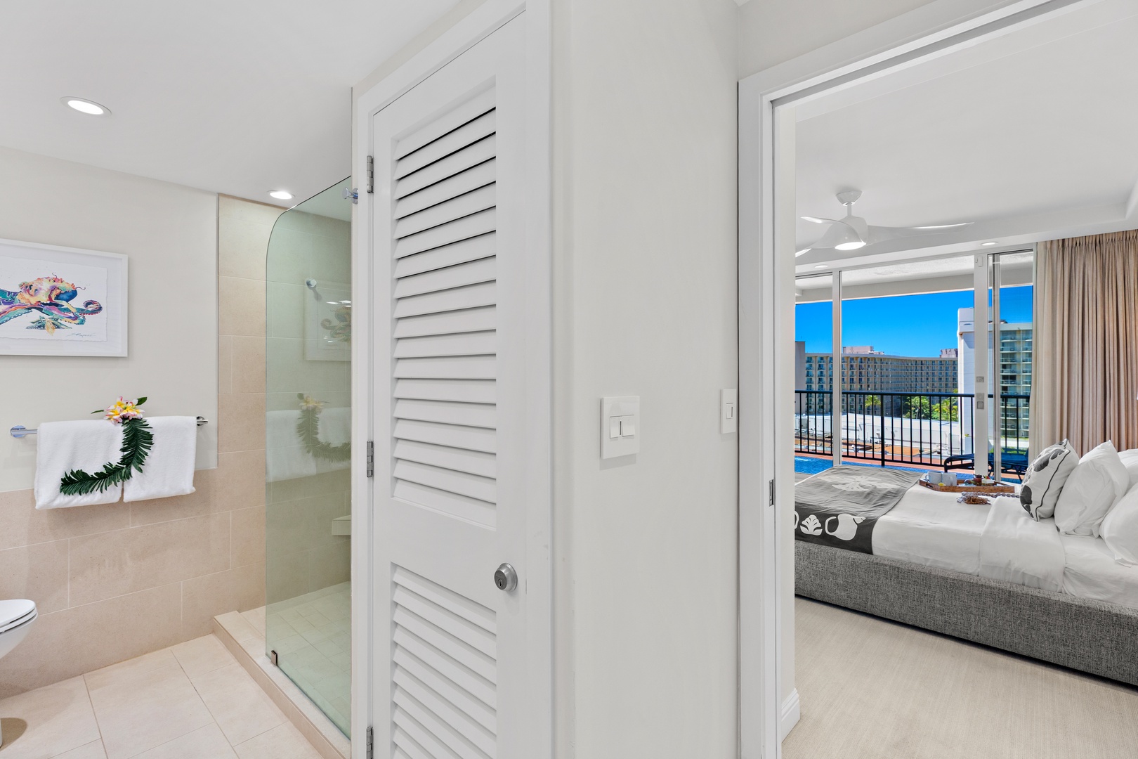 Your serene bedroom opens to a private balcony with sparkling pool and city views, while the spa-inspired bathroom offers refreshing rainfall showers and beach-themed touches.