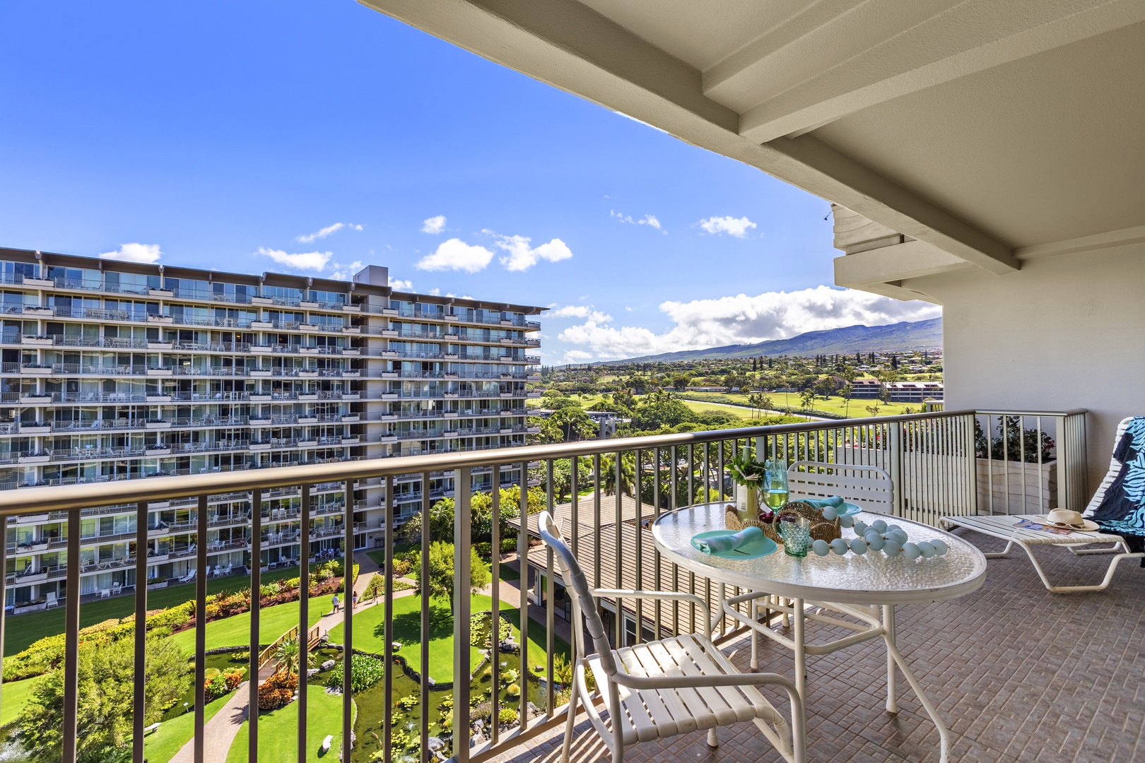 Peaceful lanai showcasing lush green mountain views alongside resort grounds from a shaded outdoor seating area.