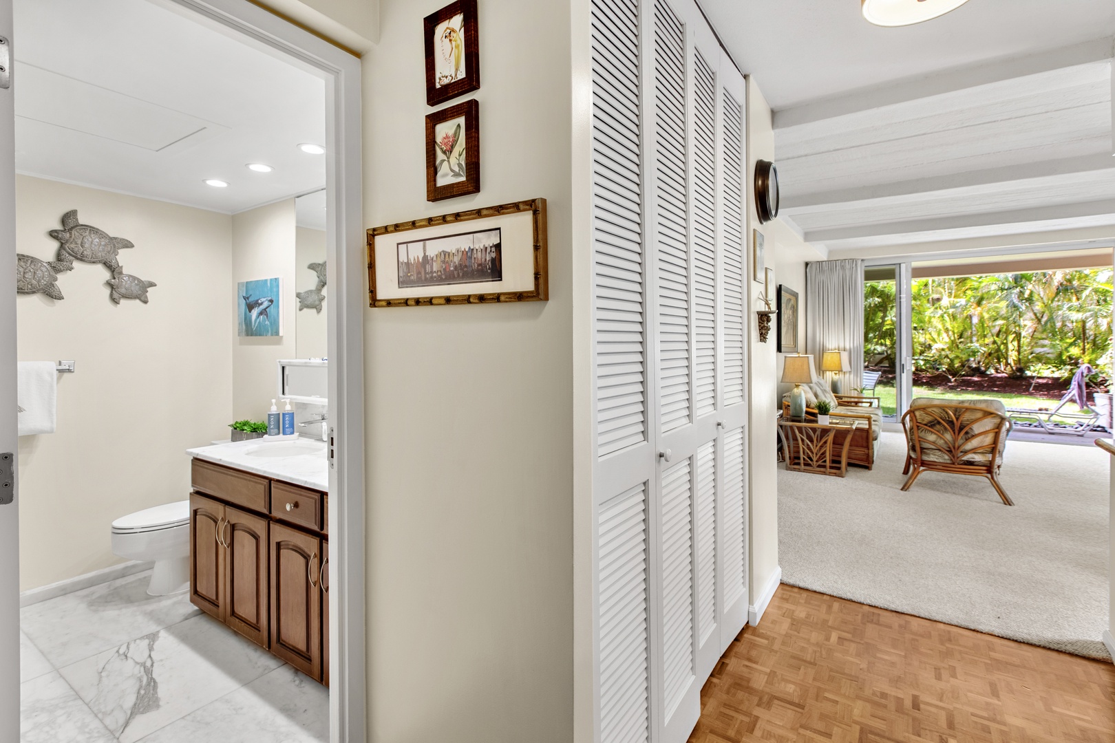 Your stylish bathroom features tropical artwork and connects seamlessly to your comfortable living space with garden views.