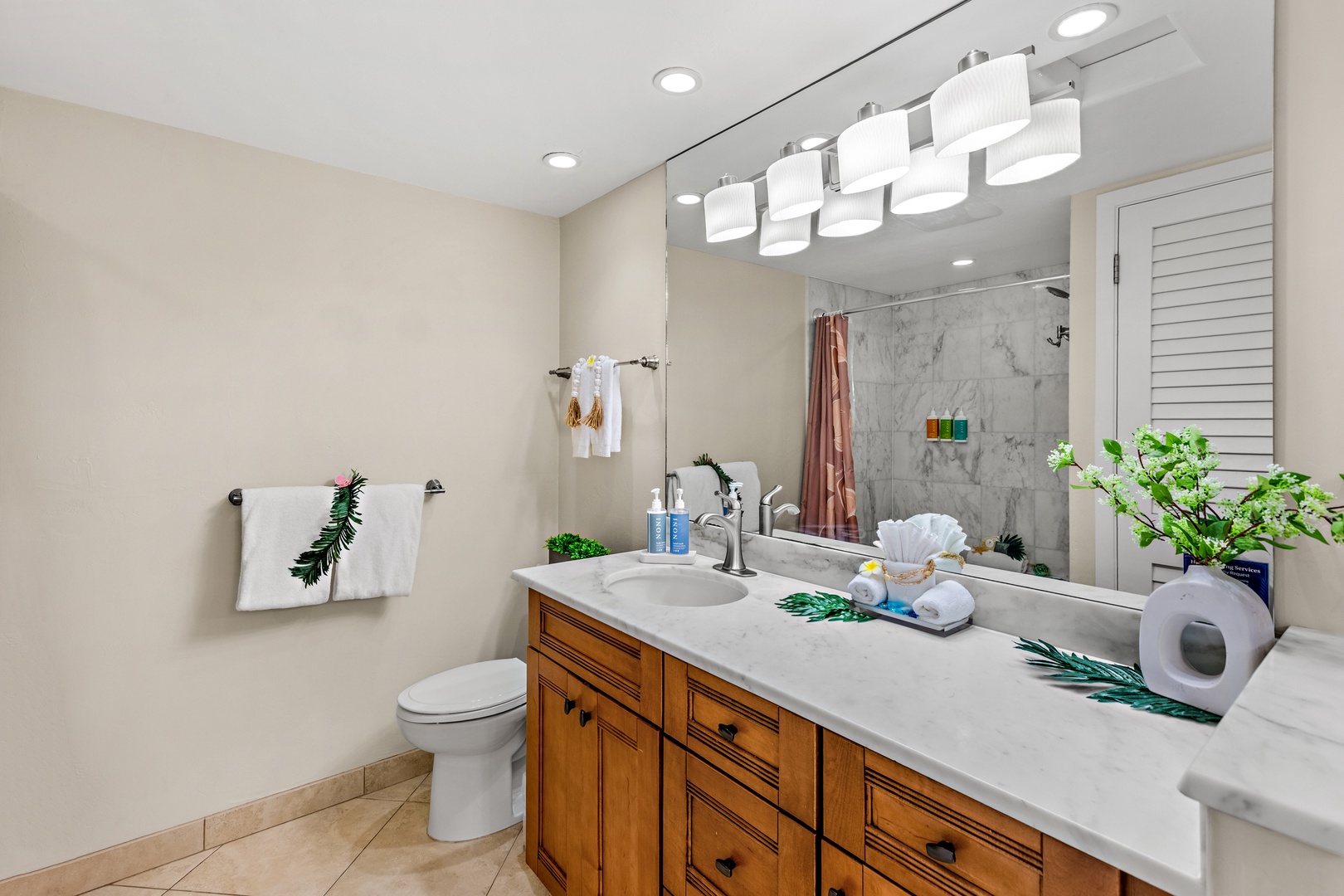 Your private bathroom features elegant marble counters, warm wood cabinetry, and spa-like lighting for your morning routines.