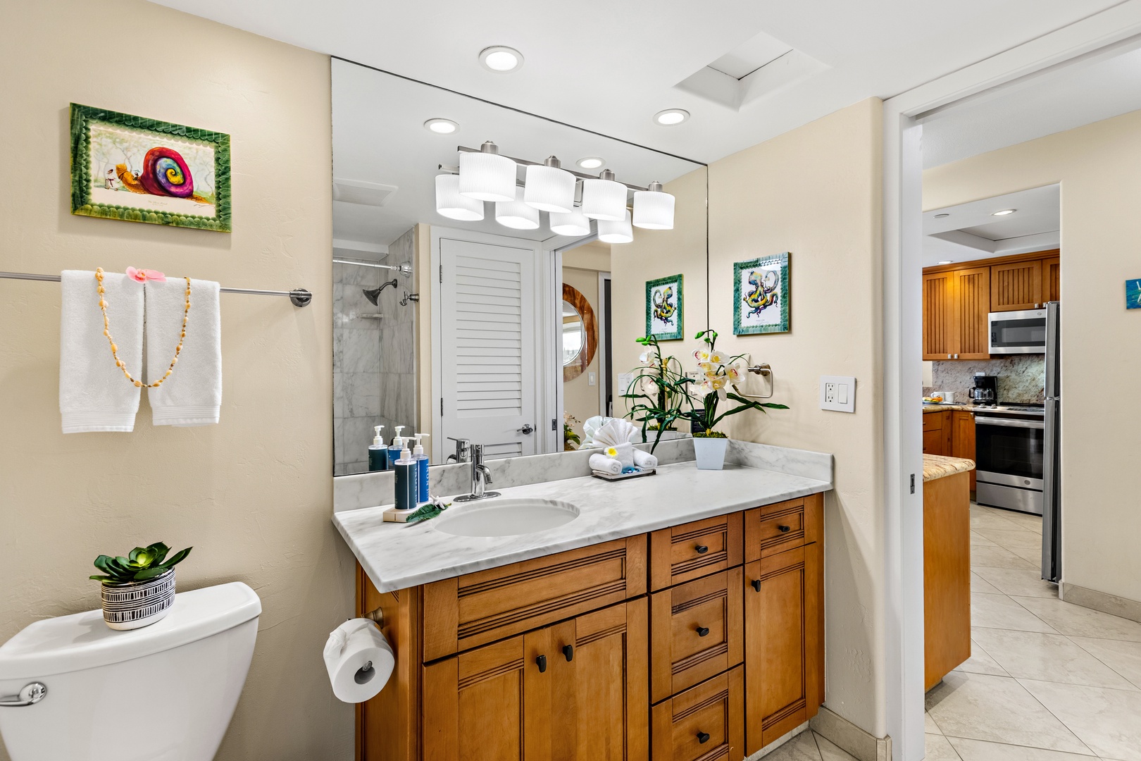 Step into your stylish bathroom with warm wood vanity, marble countertops, and modern amenities for a refreshing start to your day.