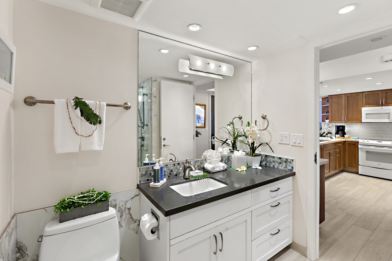 Well-appointed guest bath with crisp white cabinetry, polished fixtures, and a spacious vanity area.