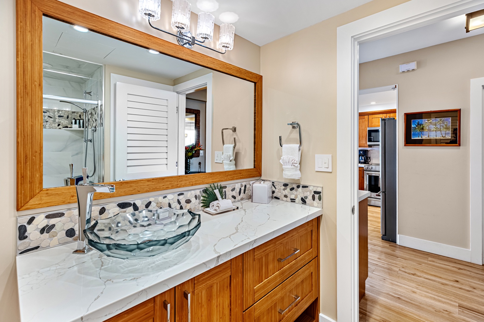 Freshen up in your stylish bathroom featuring a unique glass vessel sink, marble countertops, and warm wood cabinetry that creates a spa-like retreat.