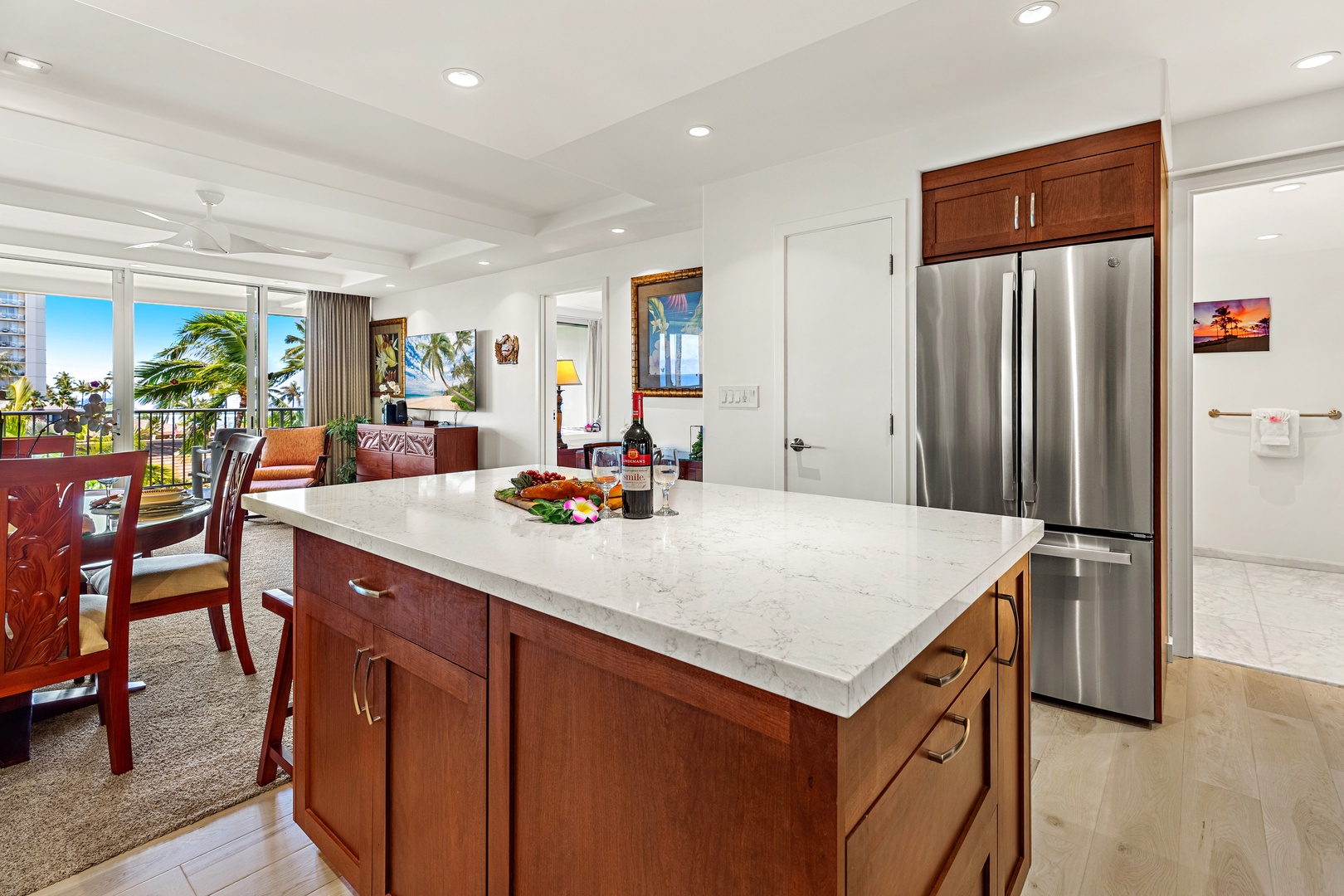 Bright and inviting open-concept kitchen featuring cabinetry, sleek countertops, and a spacious island that flows seamlessly into the living and dining areas. Perfect for entertaining or relaxing in comfort.
