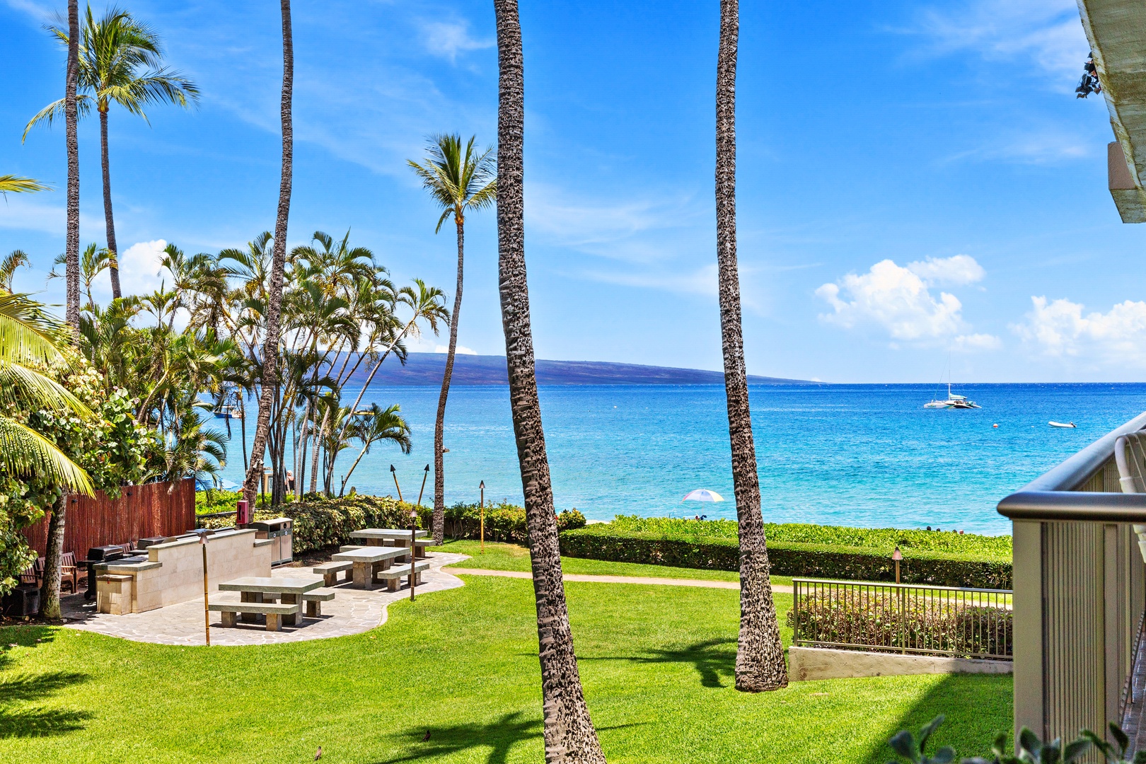 Ocean view grounds feature lush lawns, swaying palms, BBQ area, and stunning turquoise waters just steps away from your vacation retreat.