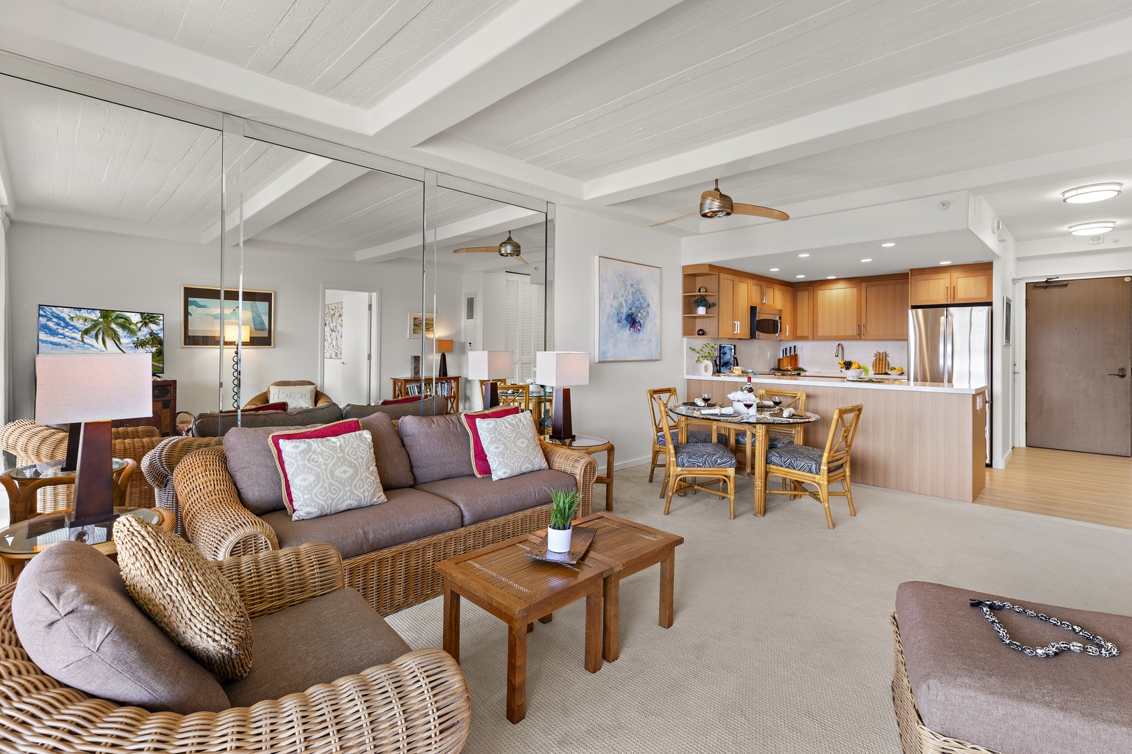 Picture yourself relaxing in this breezy open-concept space where tropical-inspired wicker seating flows into your fully equipped kitchen and dining area—perfect for unwinding after beach days.