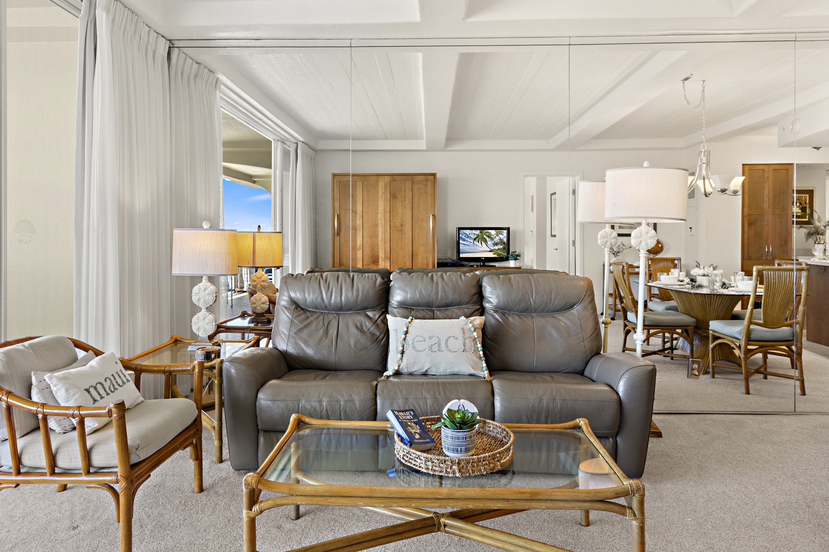 Comfortable living area with a reclining sofa, glass coffee table, and coordinated island-style décor.
