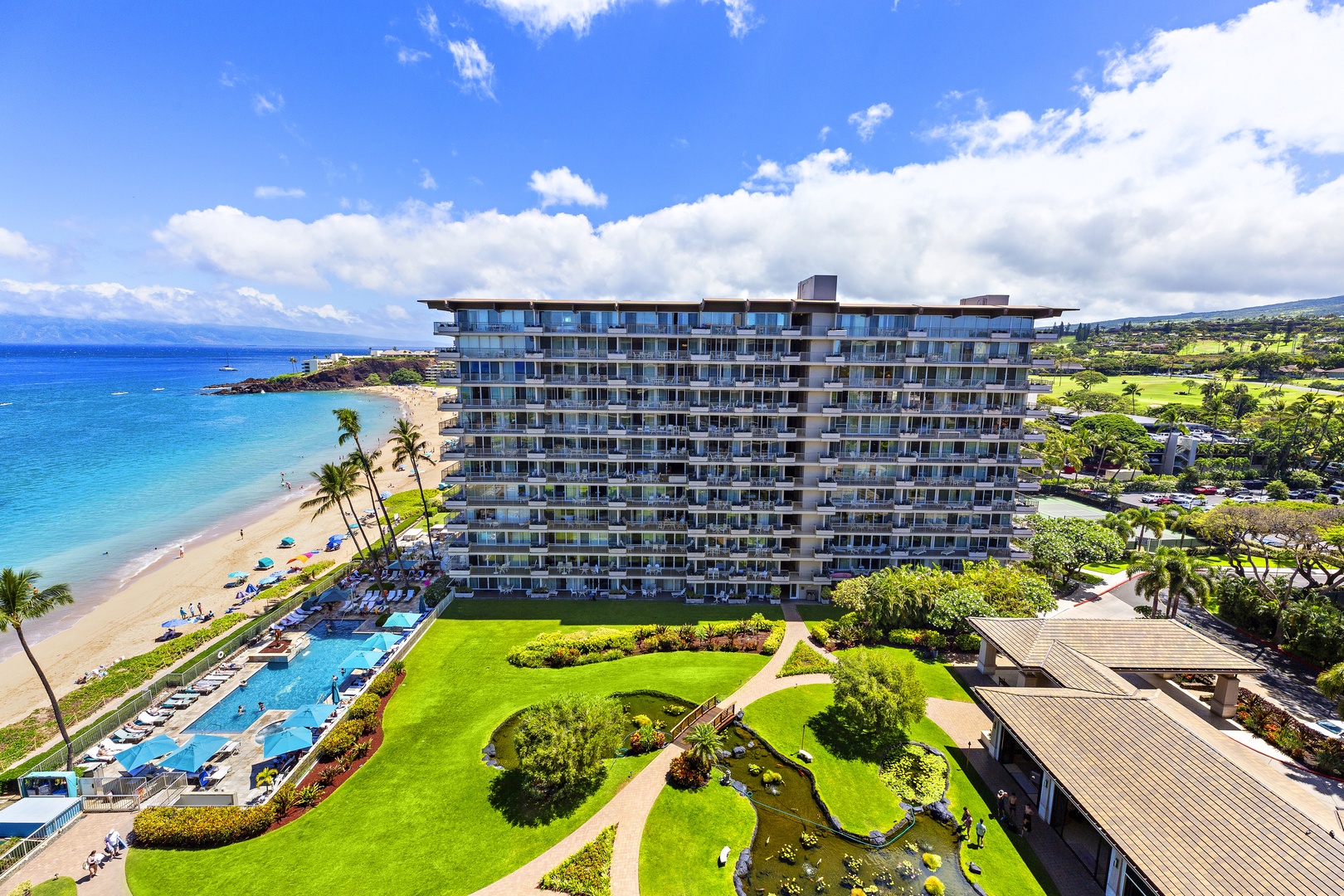 A beachfront resort property nestled along golden sands with pristine ocean waters and lush tropical gardens throughout the grounds.