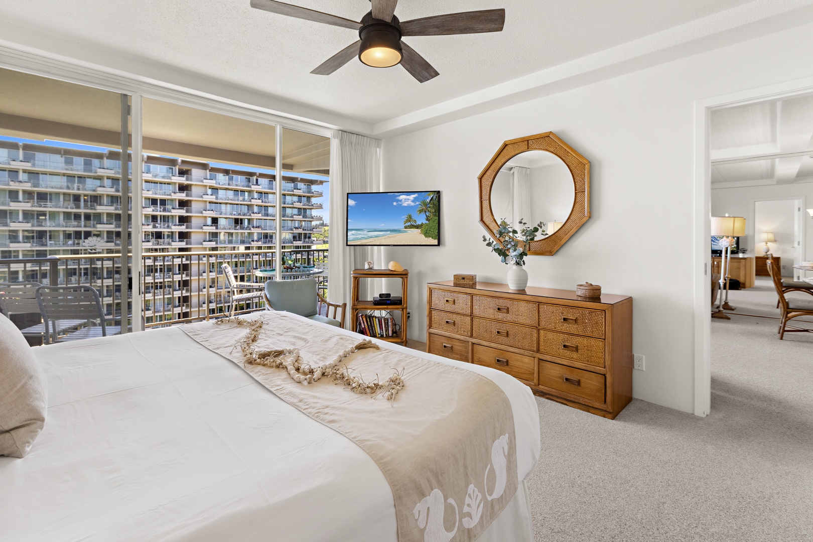 Relaxing bedroom retreat with warm wood furnishings, soft textiles, and large windows showcasing neighboring coastal scenery.