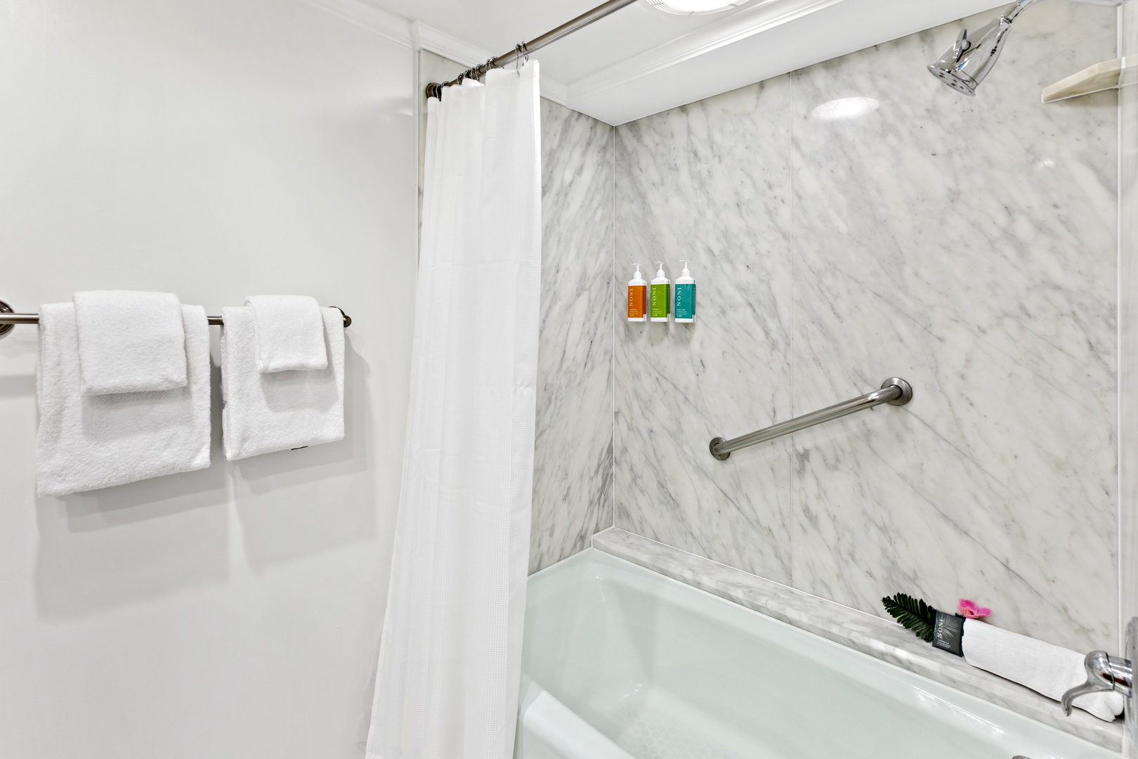 Unwind in your elegant marble bathroom featuring a deep soaking tub, rainfall shower, and premium amenities for your comfort.