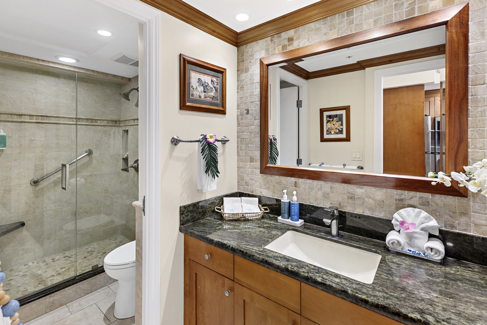 Luxurious marble bathroom with granite vanity, glass shower, and thoughtful amenities for your perfect getaway.