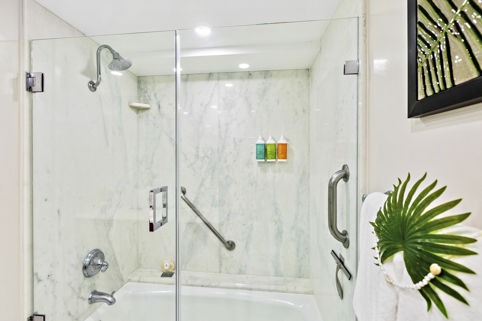 A sleek, spa-inspired walk-in shower designed for comfort and ease. Surrounded by warm, natural tile and featuring a glass enclosure, built-in bench, and modern fixtures, this space offers a relaxing retreat after a day of island adventures.