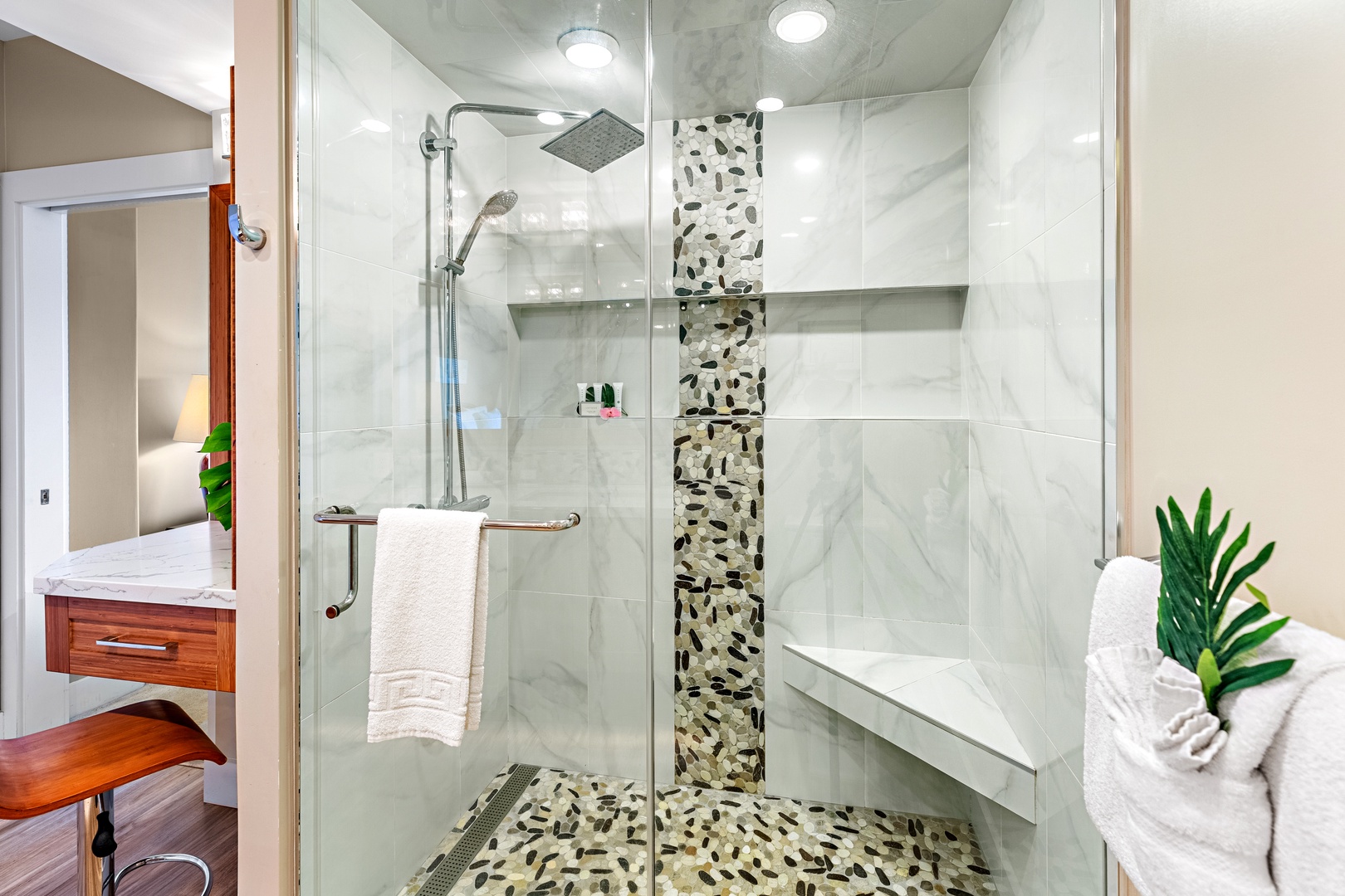 Step into your spa-like rainfall shower with stunning pebble accents and marble walls for a refreshing, luxurious experience.